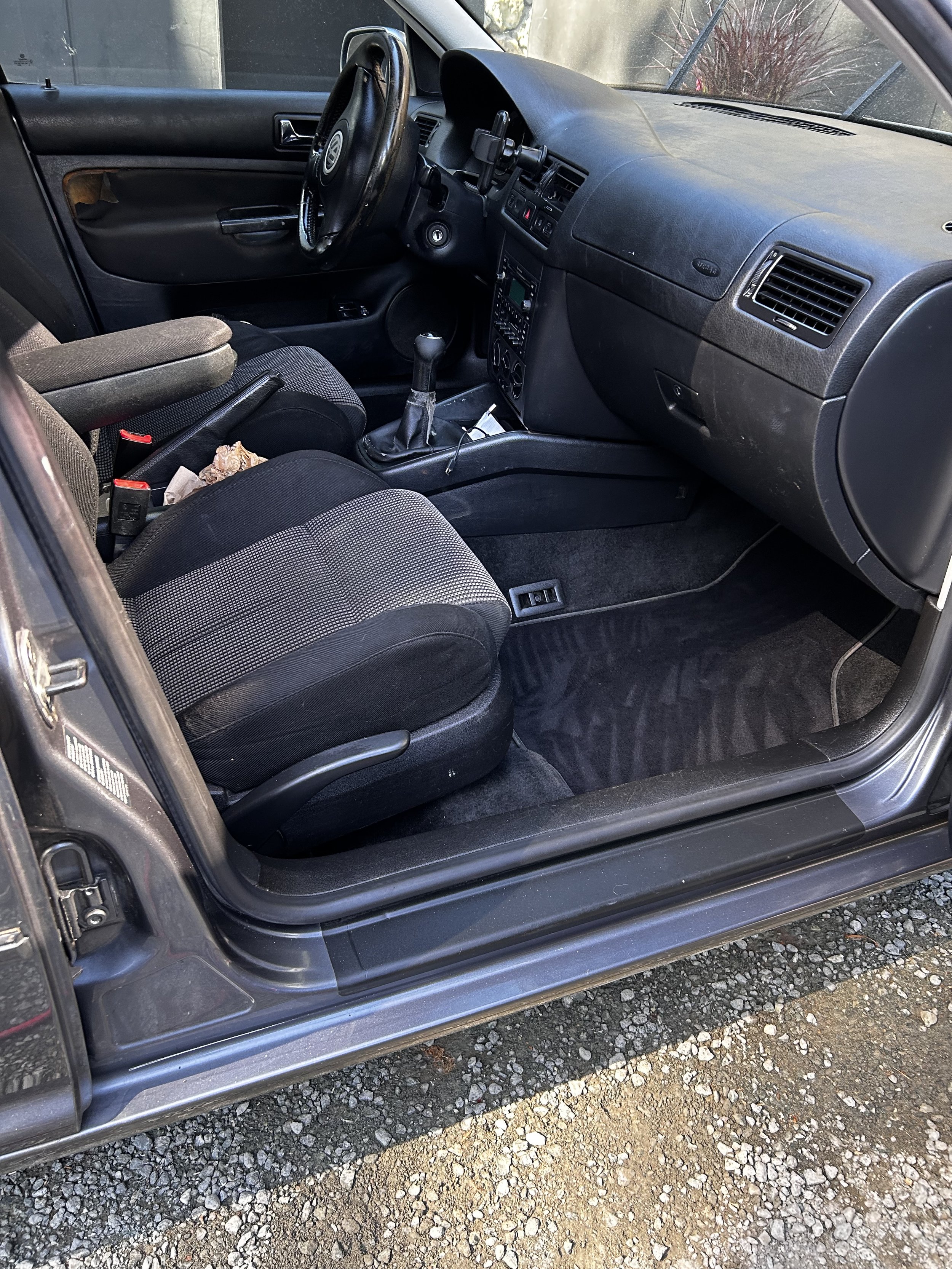 The interior of a Volkswagen car showing the dashboard, steering wheel, gear shift, front seats, and part of the door panel.