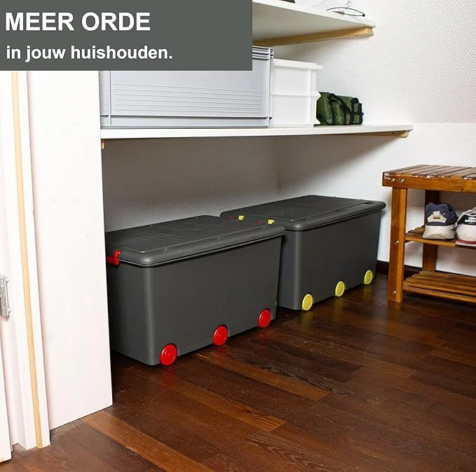 Twee zwarte afvalbakken met rode en gele wieltjes onder een witte plank, in een huishal met een houten vloer en schoenen op een houten schoenrek.