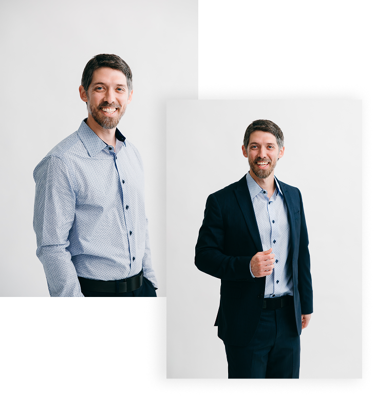 Two men smiling, one in casual business attire and the other in a suit, standing against a plain white background.