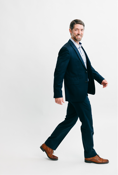 conrad bear in a blue suit walking to the right