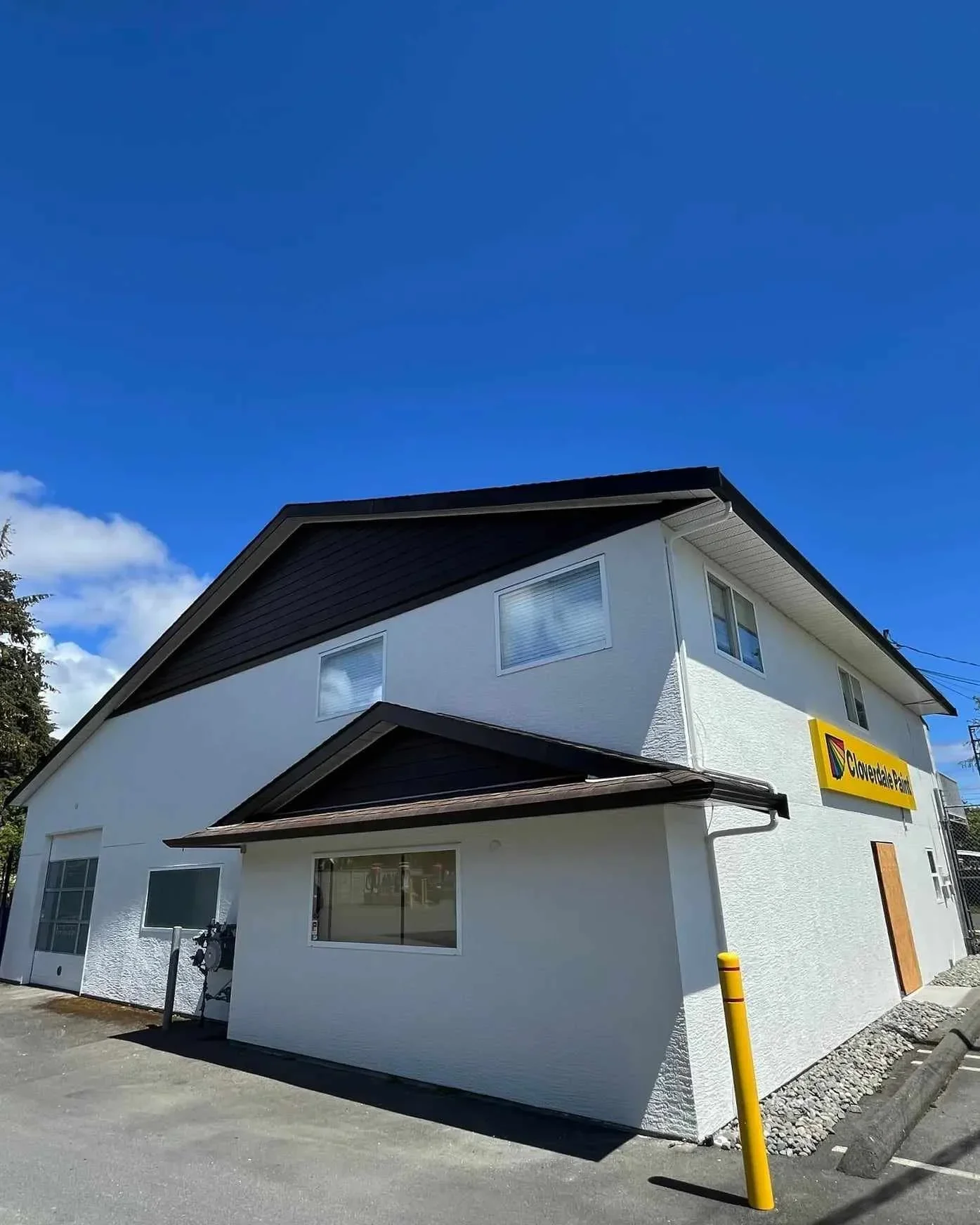 Blue house under construction with a new porch and steps, surrounded by dirt, with a partly cloudy sky.