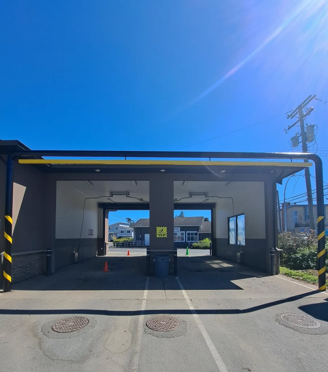 A freshly painted  parking bay with a barrier gate and traffic cones under a bright blue sky