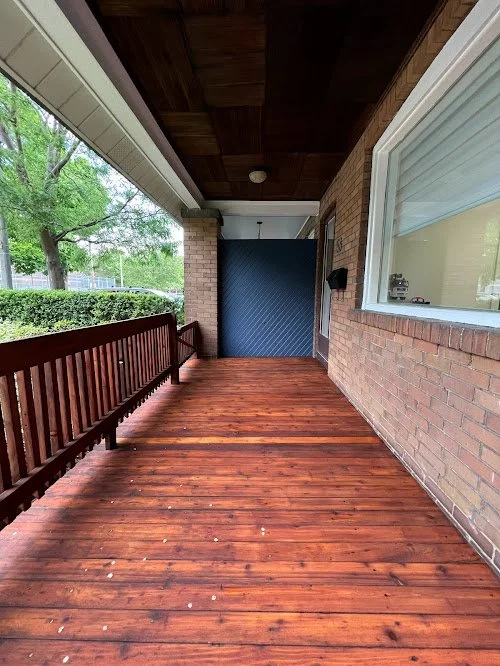 Residential porch wood refinishing including sanding, repairs, and premium stain finish