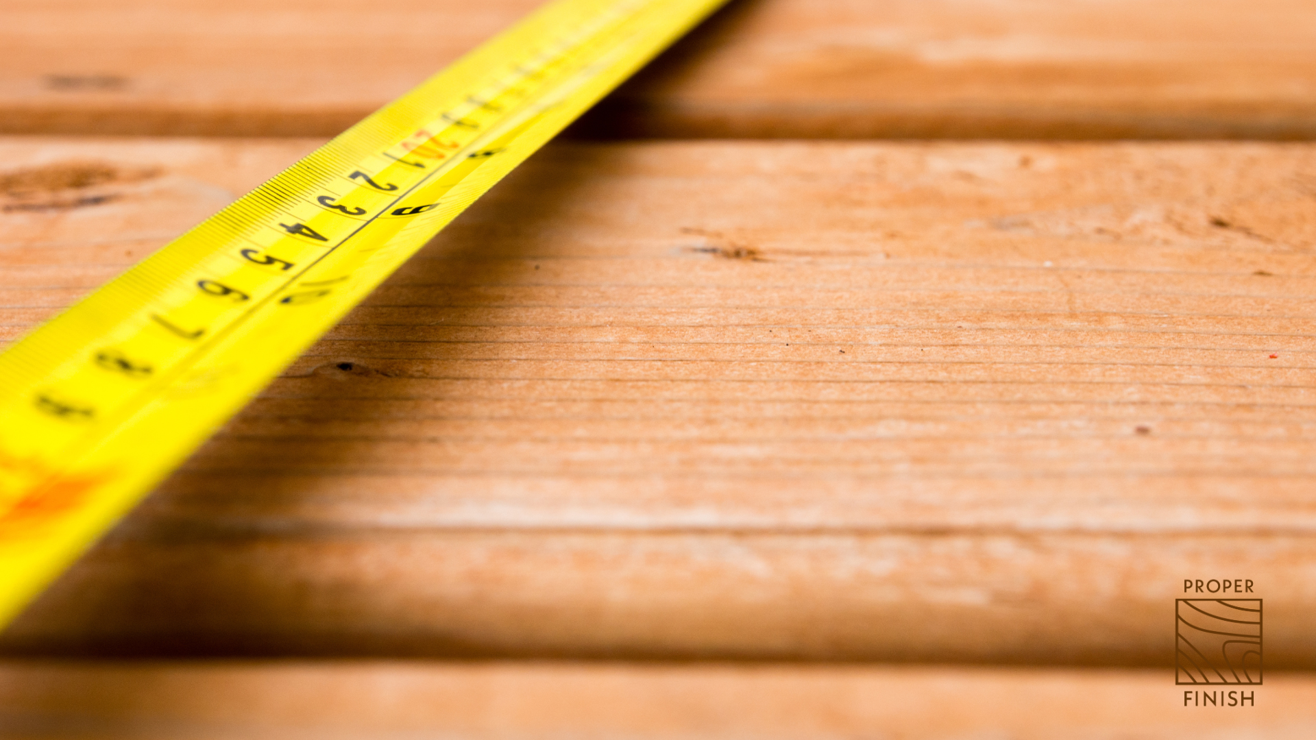 Close-up of a yellow measuring tape on a wooden surface.