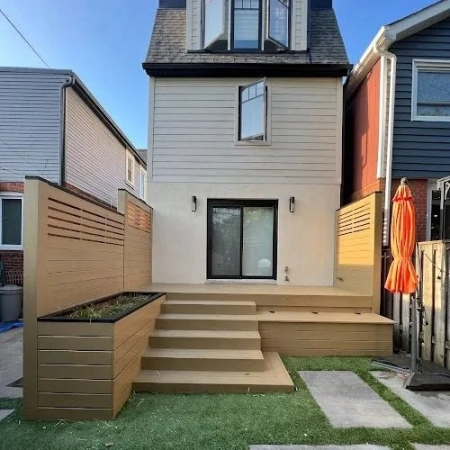 Softwood deck maintenance in Toronto improving safety through cleaning and surface prep. Backyard with a set of stairs leading to a sliding glass door, surrounded by a beige privacy fence.