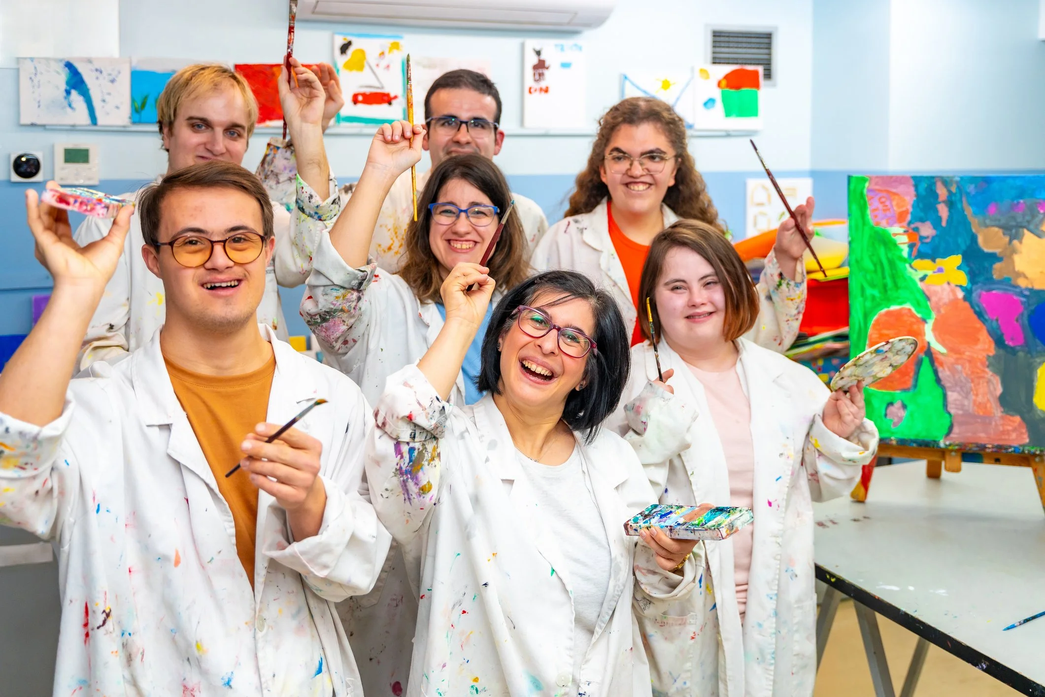 community art class with participants displaying painting tools and artwork
