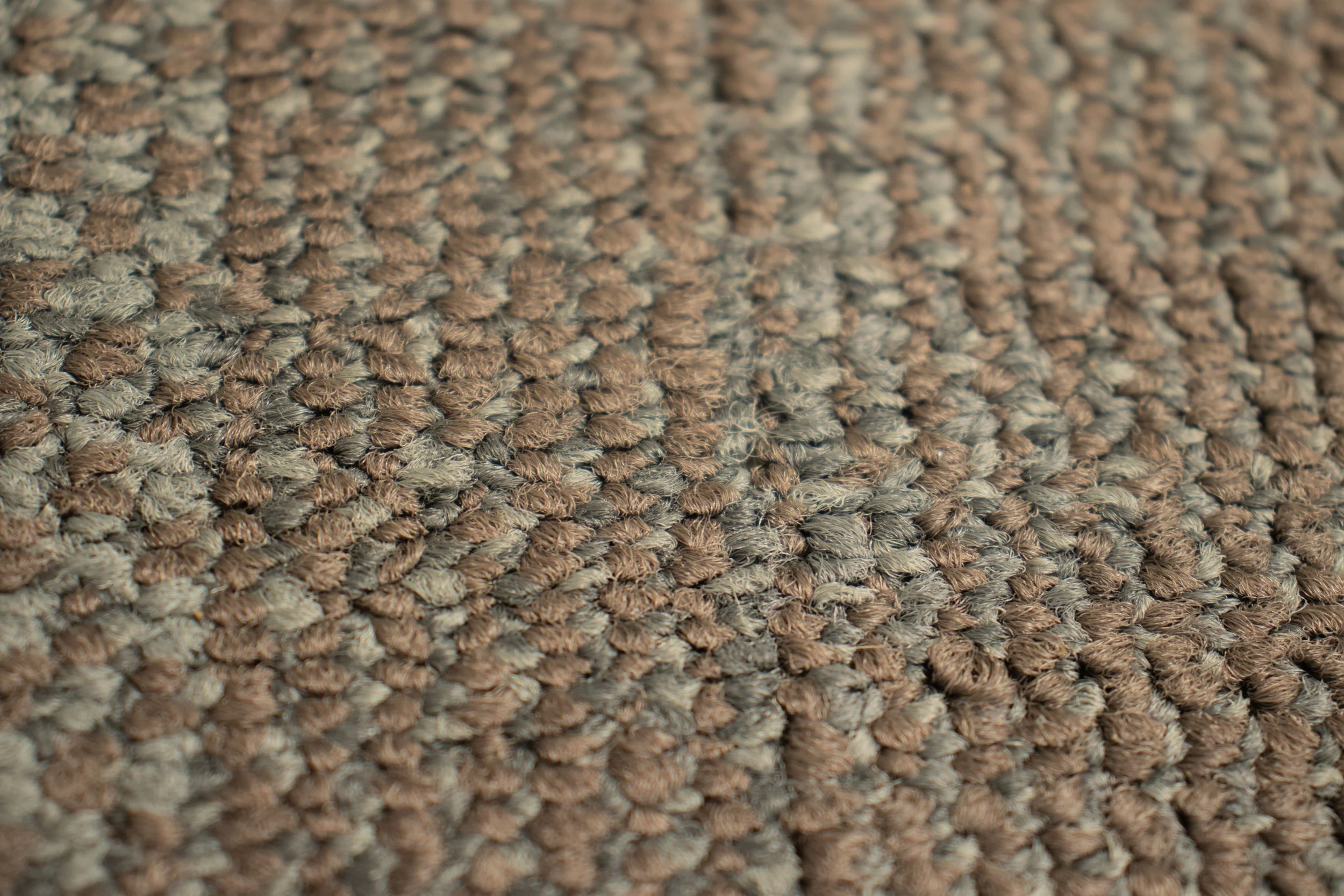 Close-up of a textured brown and gray woven carpet.