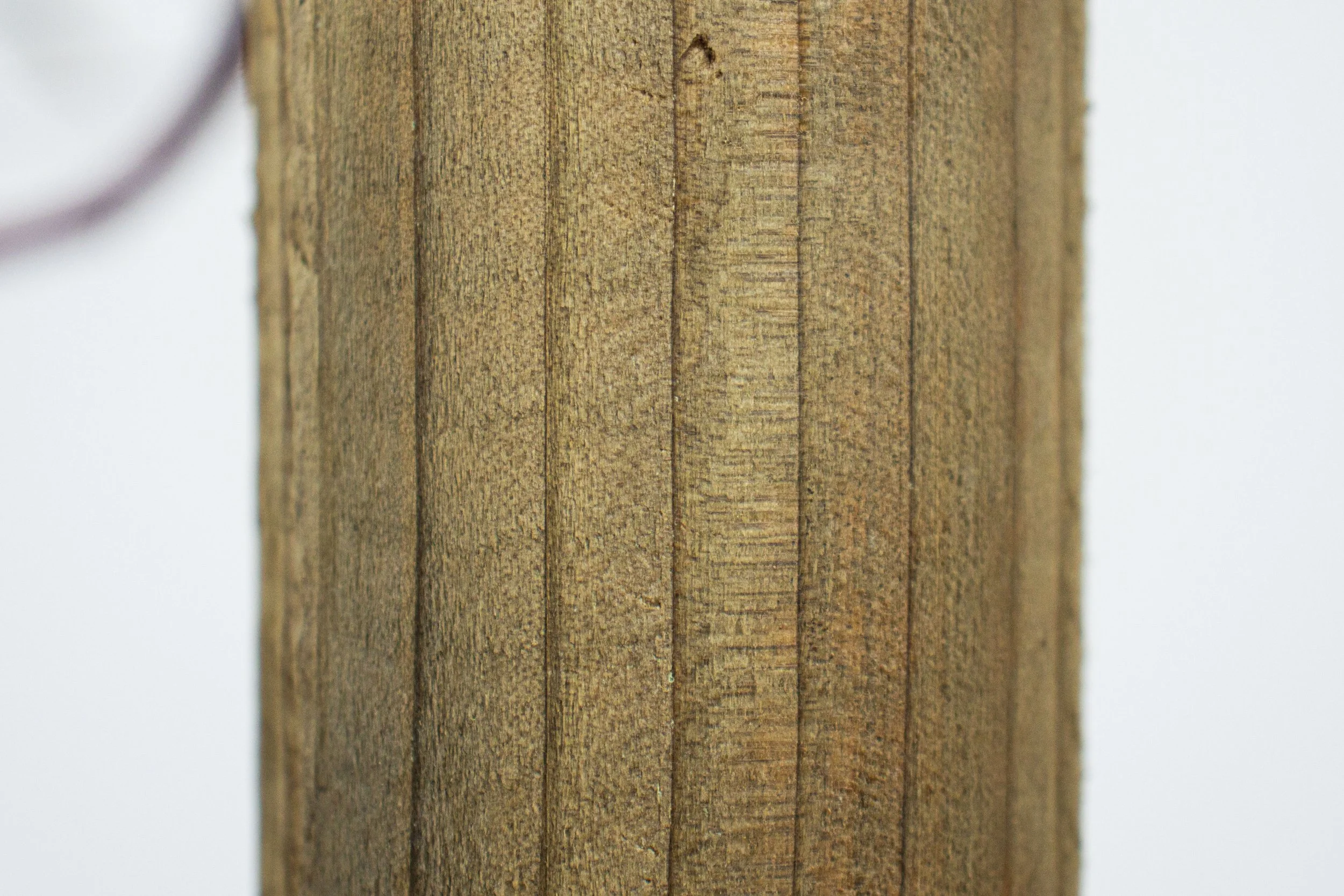 Close-up of a wooden post showing the grain and texture of the wood.