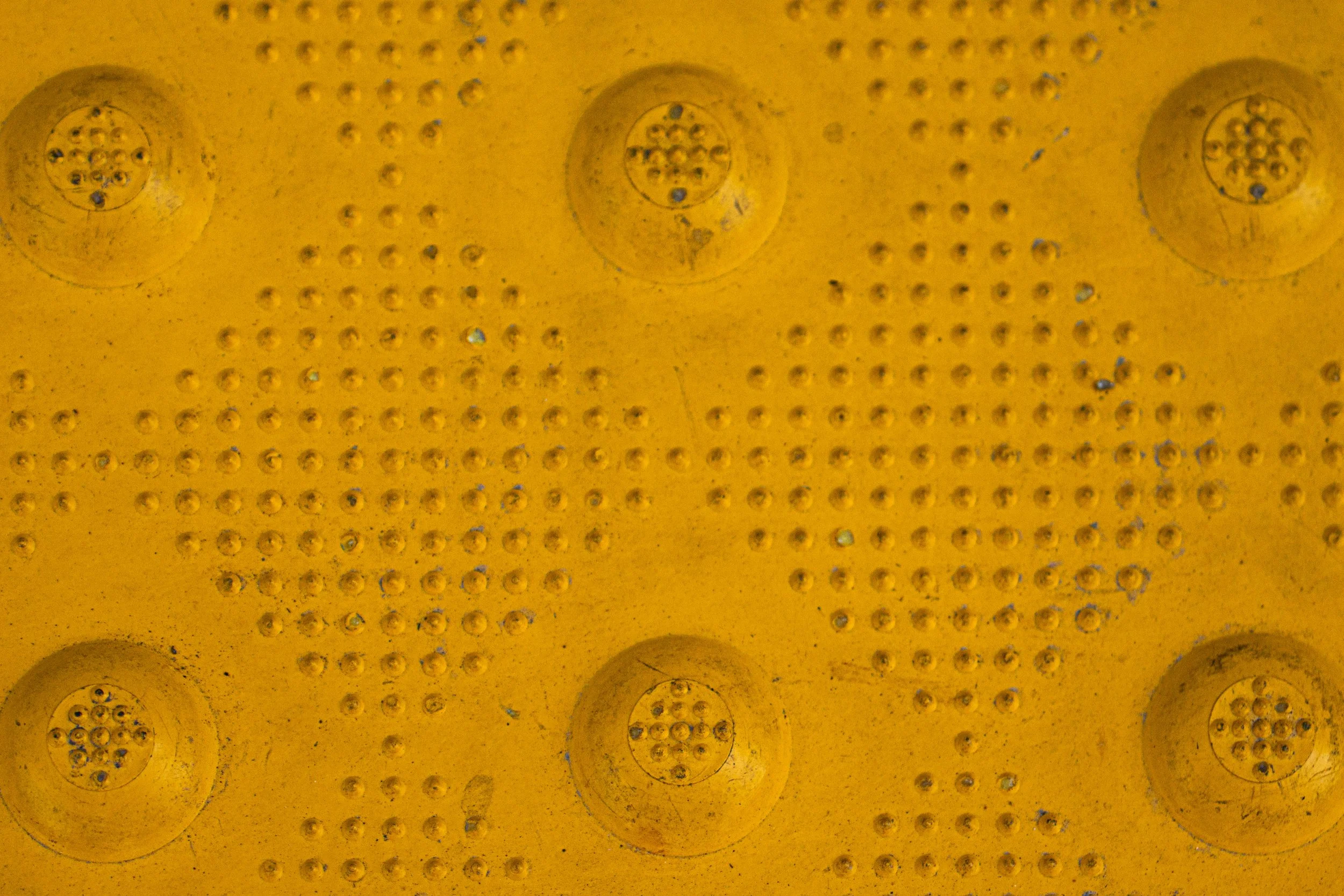 Yellow textured surface with circular and dotted patterns.