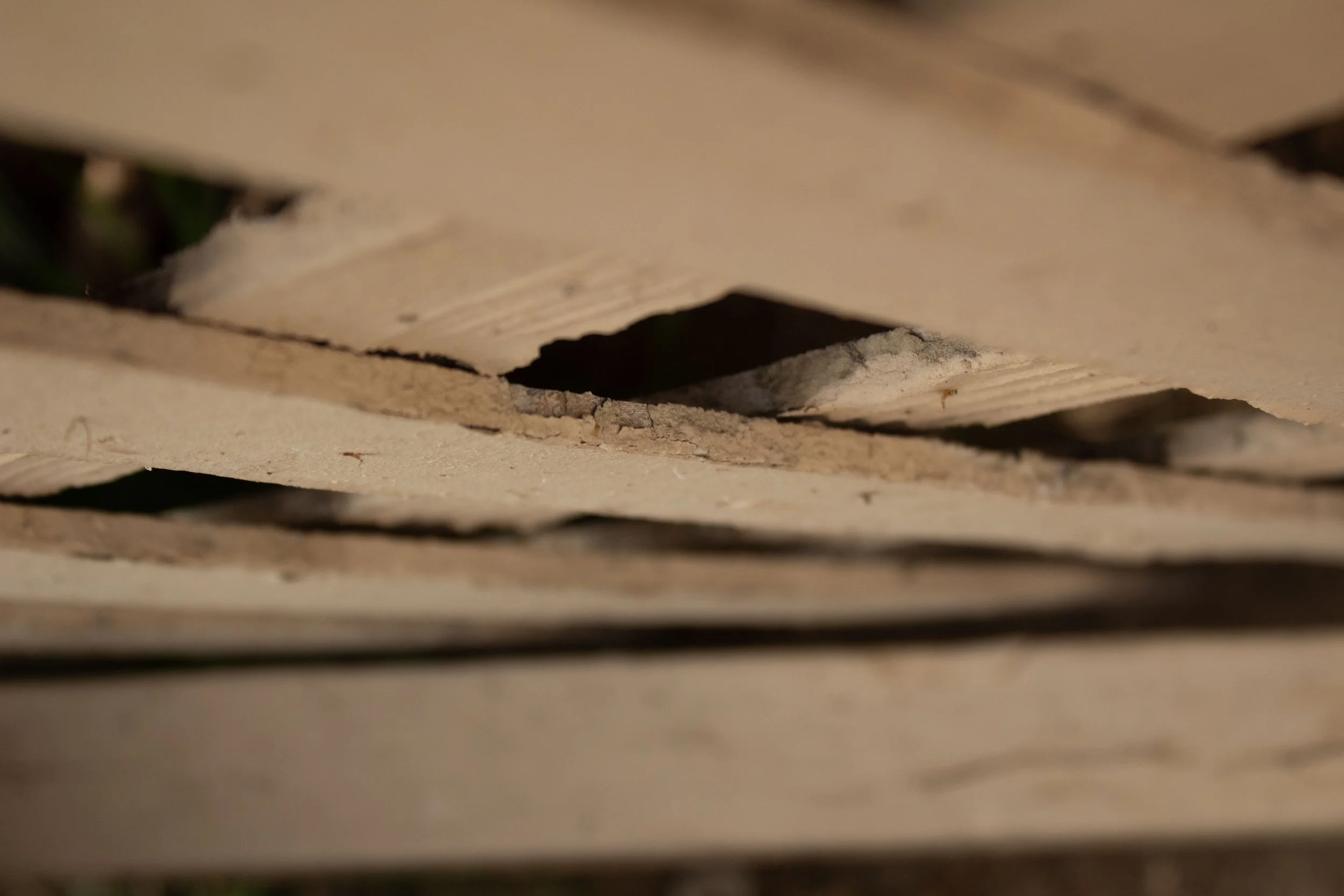 Close-up of a damaged wooden pallet with a large hole and splintered edges.