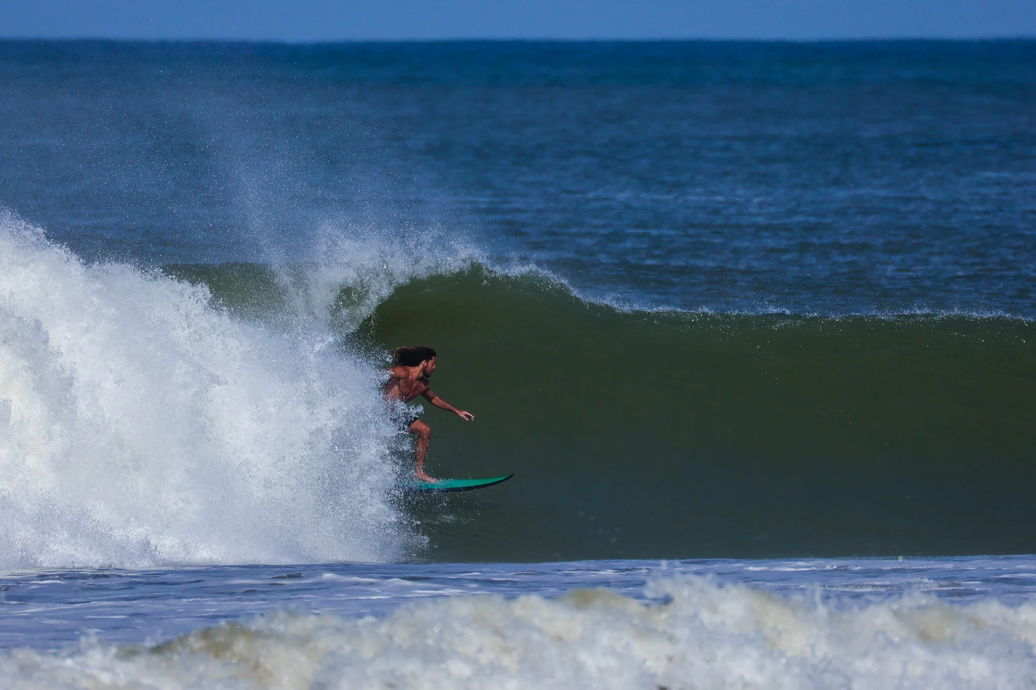A person surfing on a wave in the ocean.