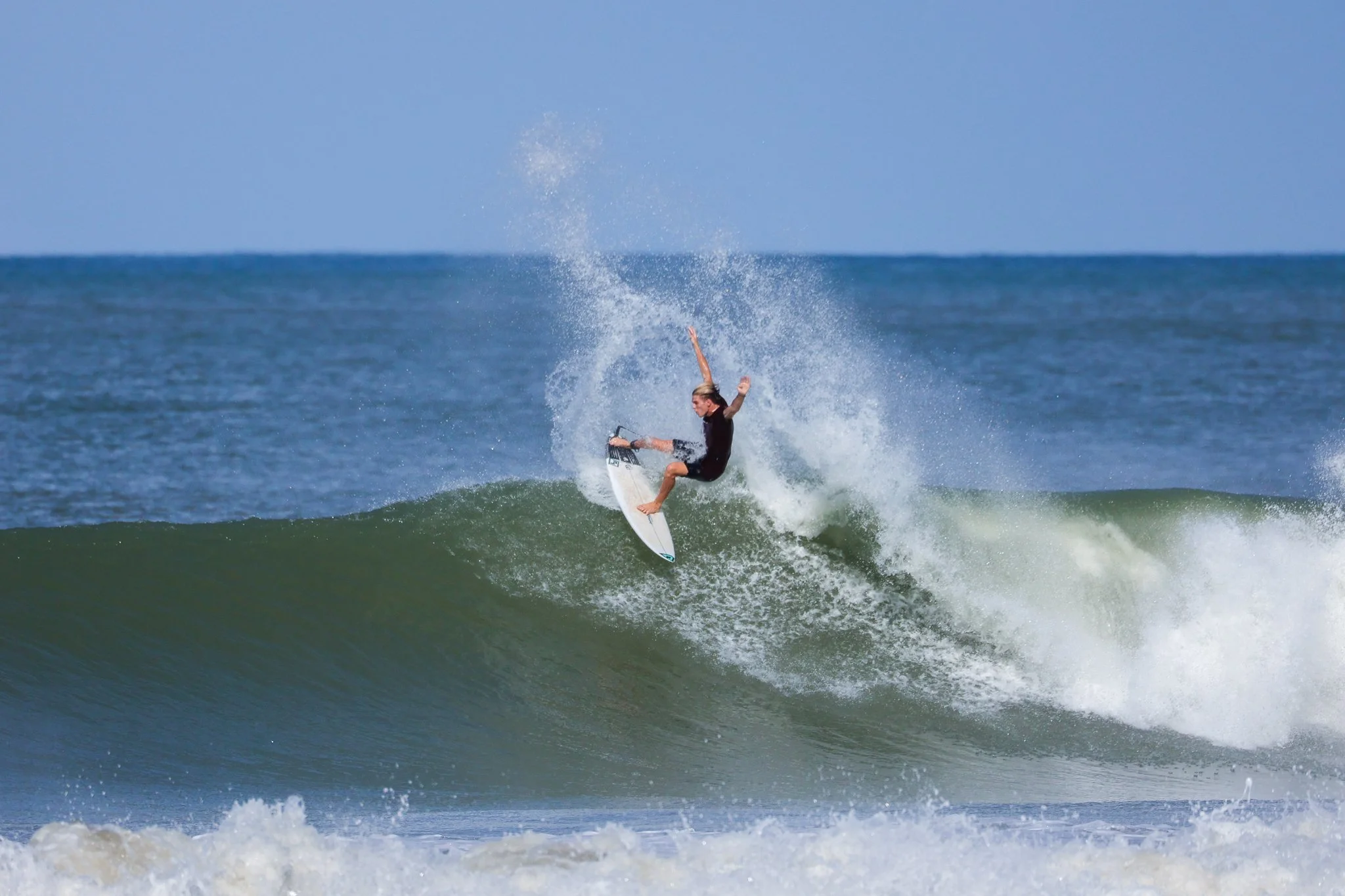 A person surfing on a wave in the ocean during daytime.