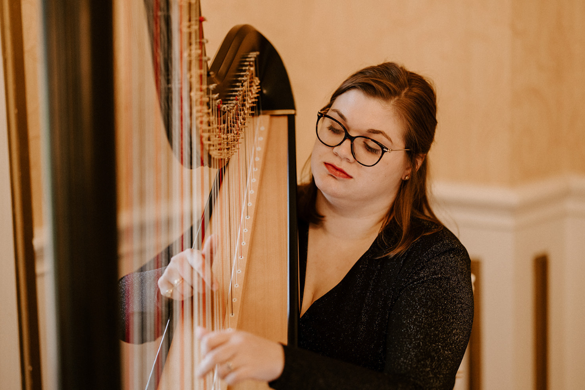 Woman with glasses playing a harp
