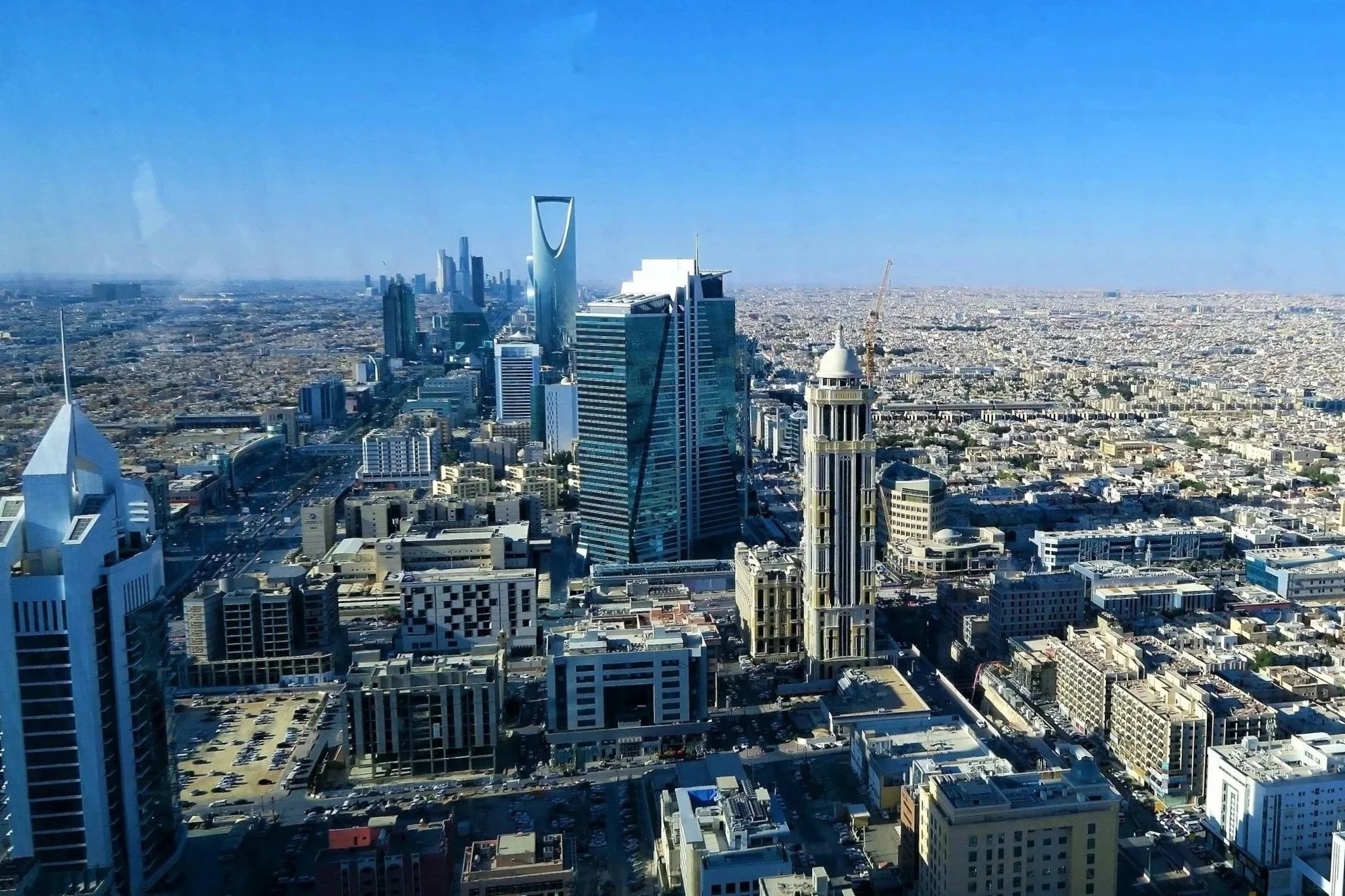 Vue aérienne de la ville de Riyad avec des gratte-ciel modernes sous un ciel dégagé.