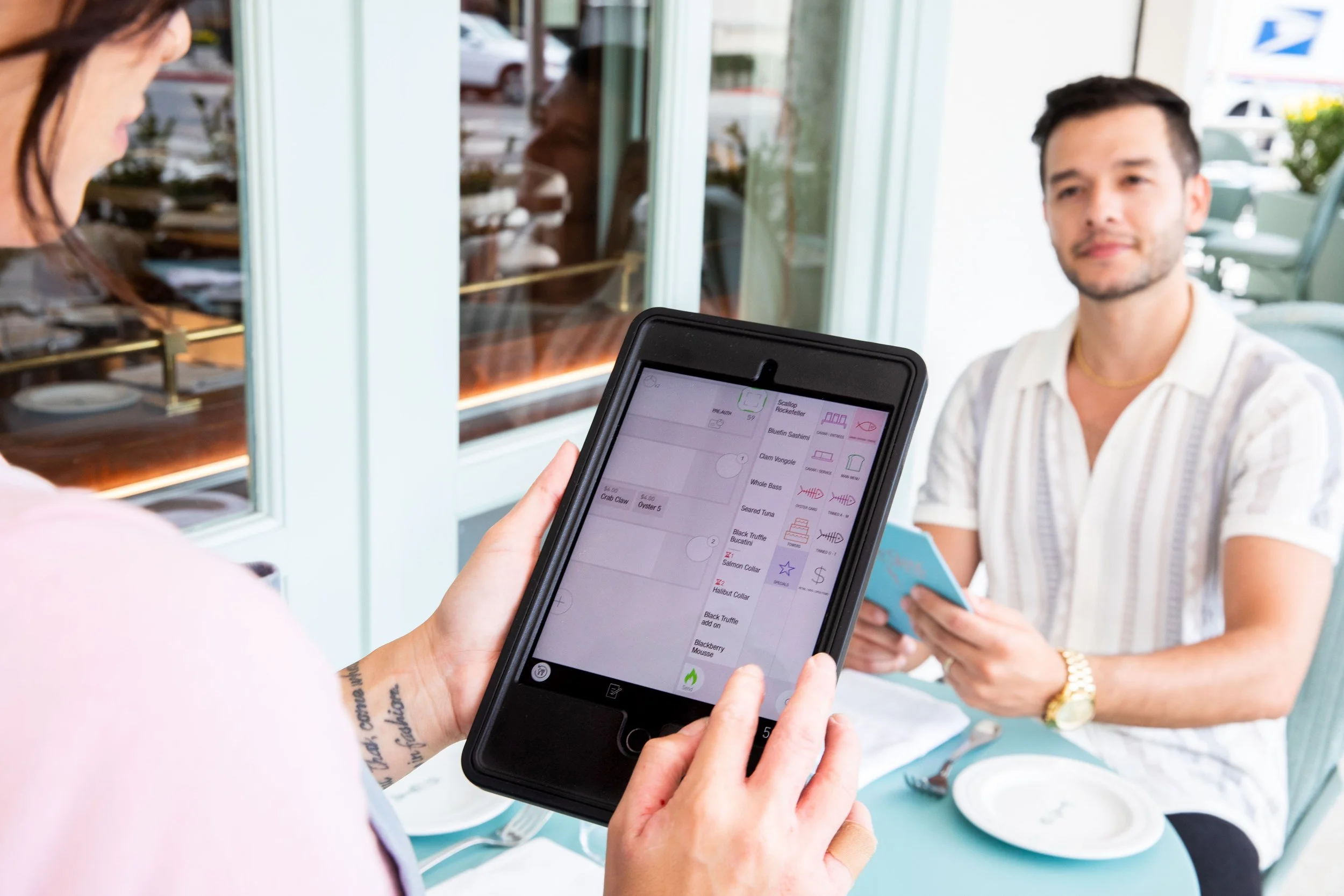 Server taking a customer's order with a tablet