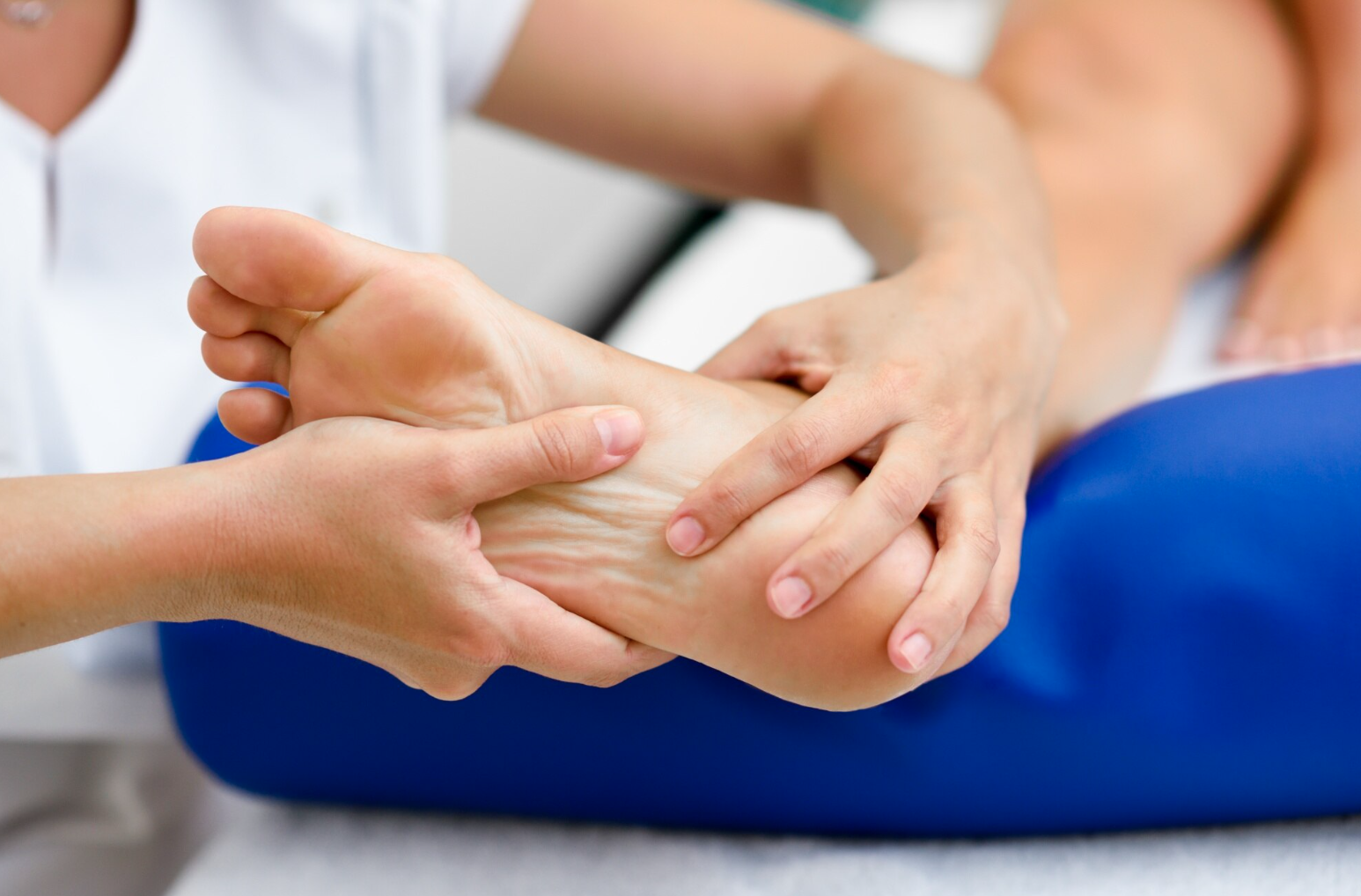 A person receiving physical therapy on their ankle, lying on a treatment table.