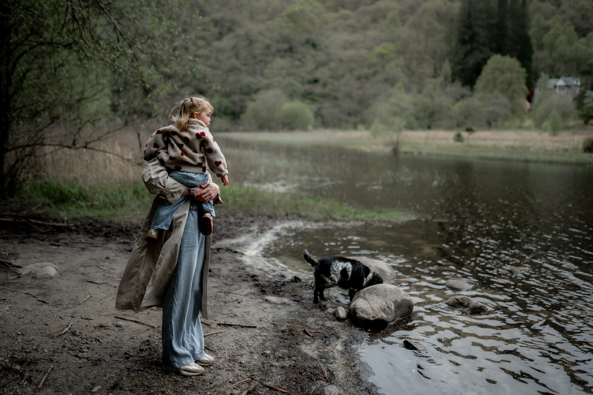 a natural and candid family photo of mum with little girl and dog by loch ard in the highlands, Scotland for their family photoshoot