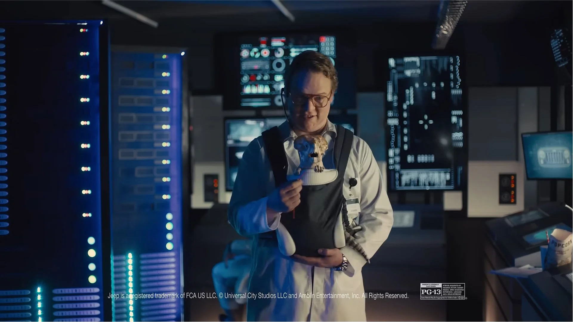 A man in a white shirt and glasses holding a fake baby tiger in a high-tech server room with multiple monitors and server racks.