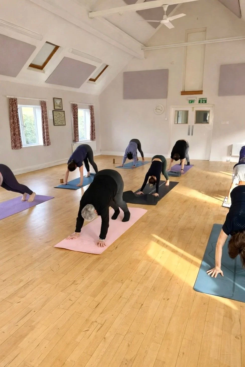 Small group yoga class in a bright village hall space in the North Cotswolds.