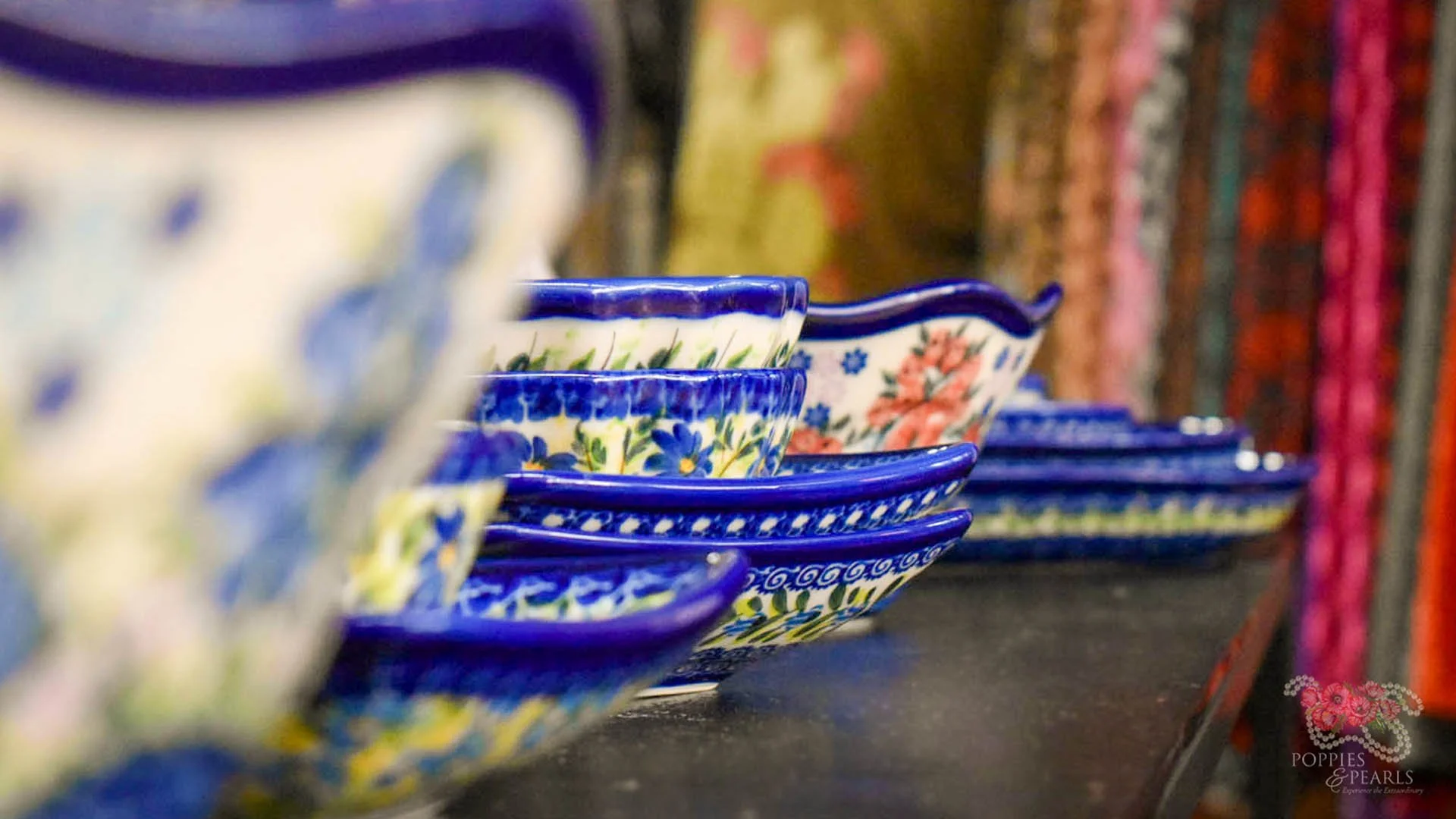 Colorful ceramic bowls with floral and decorative patterns displayed in a row on a dark surface.