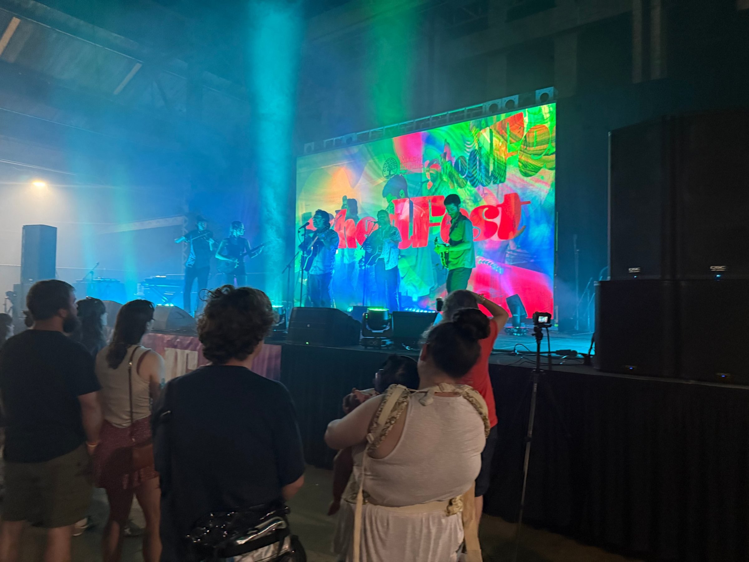 Crowd in front of anBluegrass band on an indoor festival stage with LED wall, haze and stage lighting outdoor concert stage with live band, sound by Road Ready Production Resources