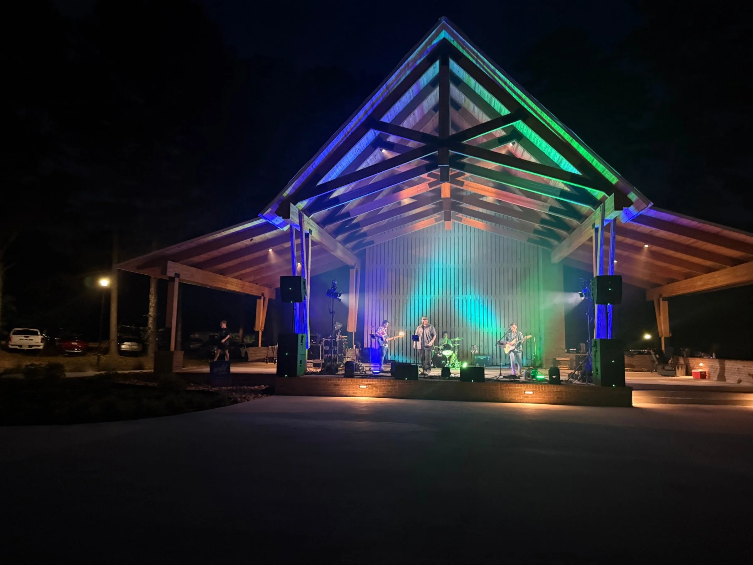 Live band on a lit outdoor pavilion stage at a Night Market concert produced by Road Ready Production Resources