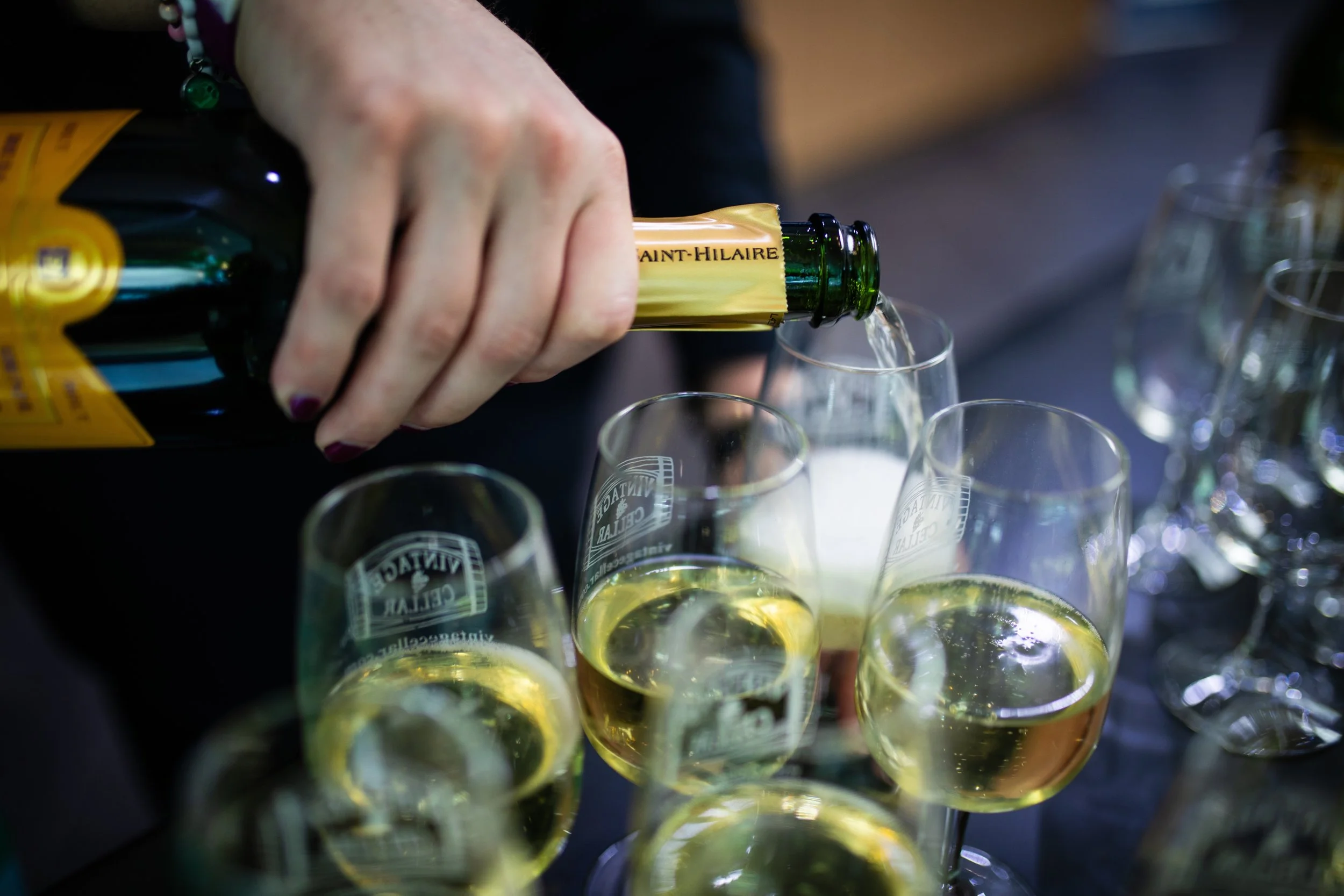 Person pouring champagne into glasses at a celebration.