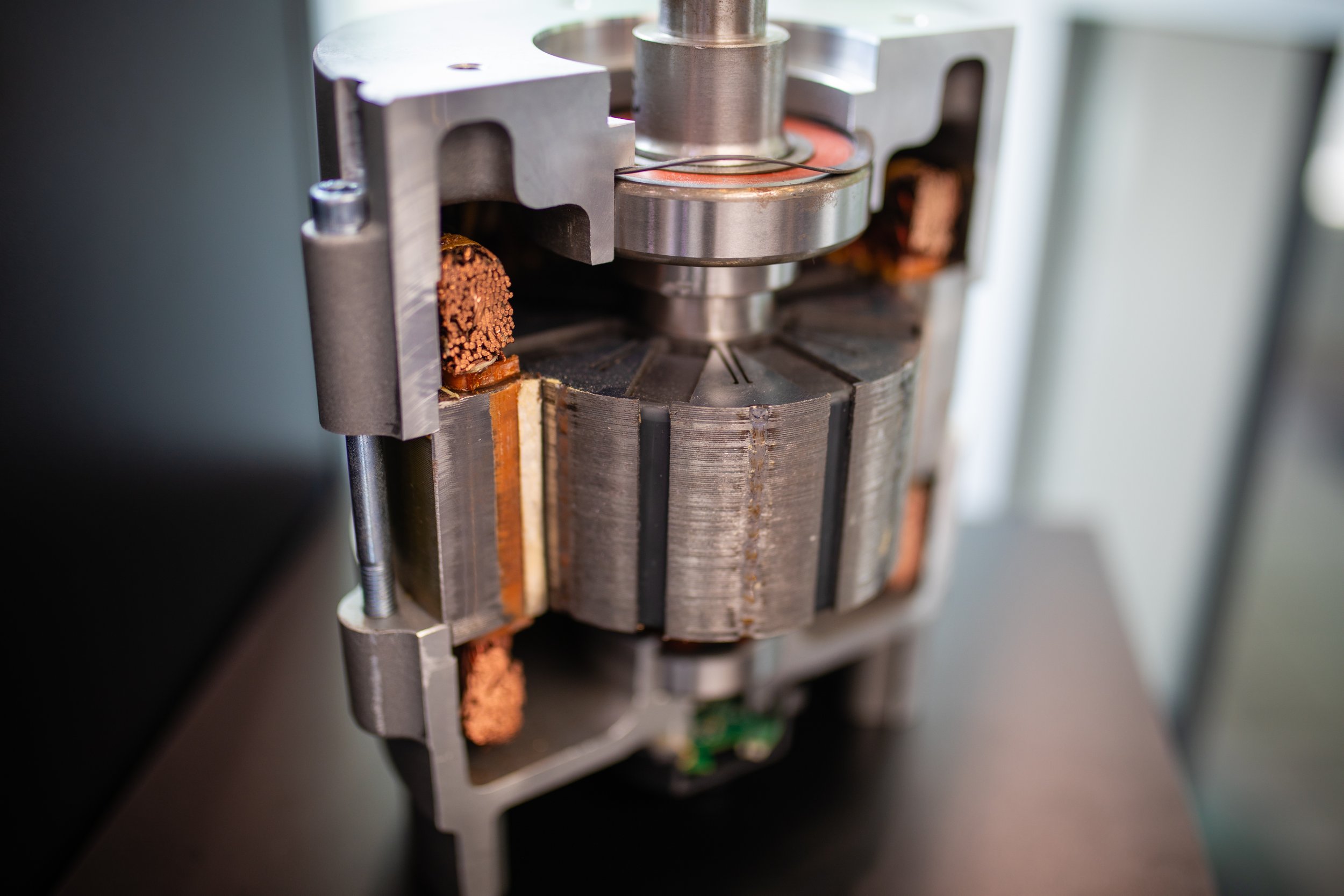 Close-up of an industrial machine part with metal components and copper elements, possibly a motor or a grinder.