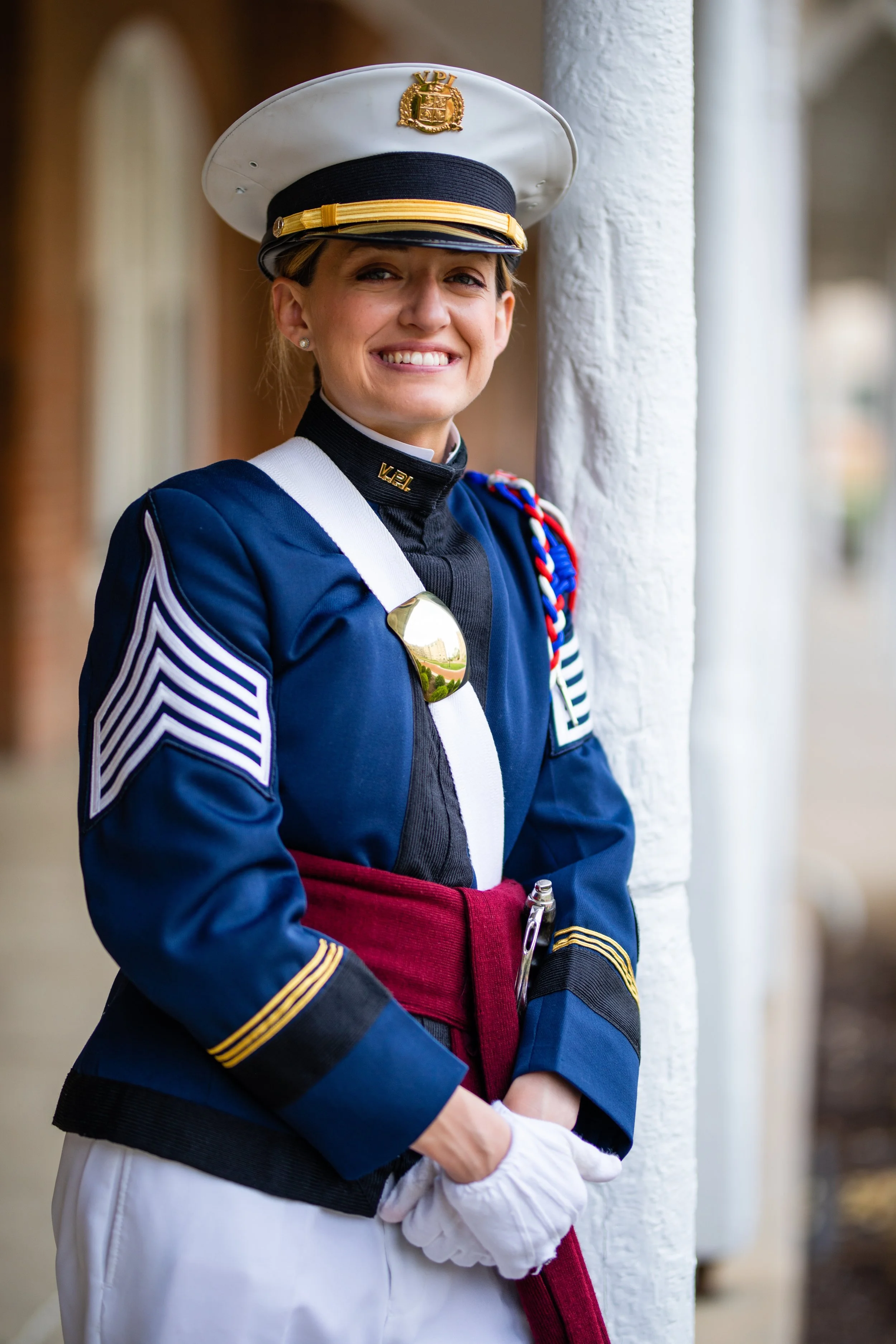 Woman in a United States Marine Corps dress uniform smiling while standing outdoors.