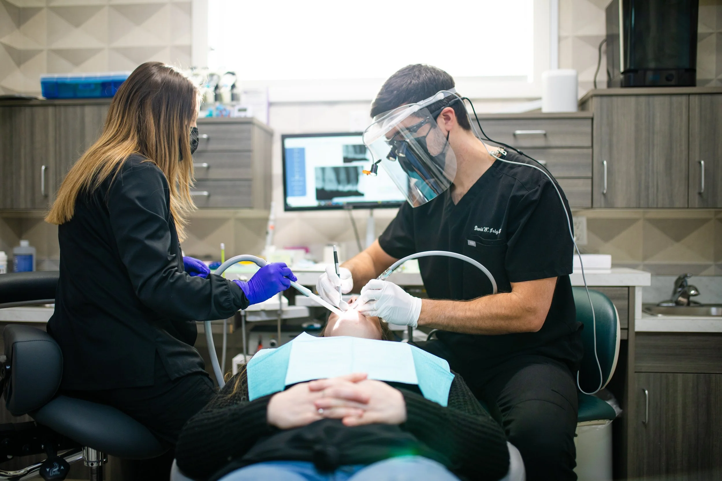Dentists performing dental procedure on a patient in a dental clinic.