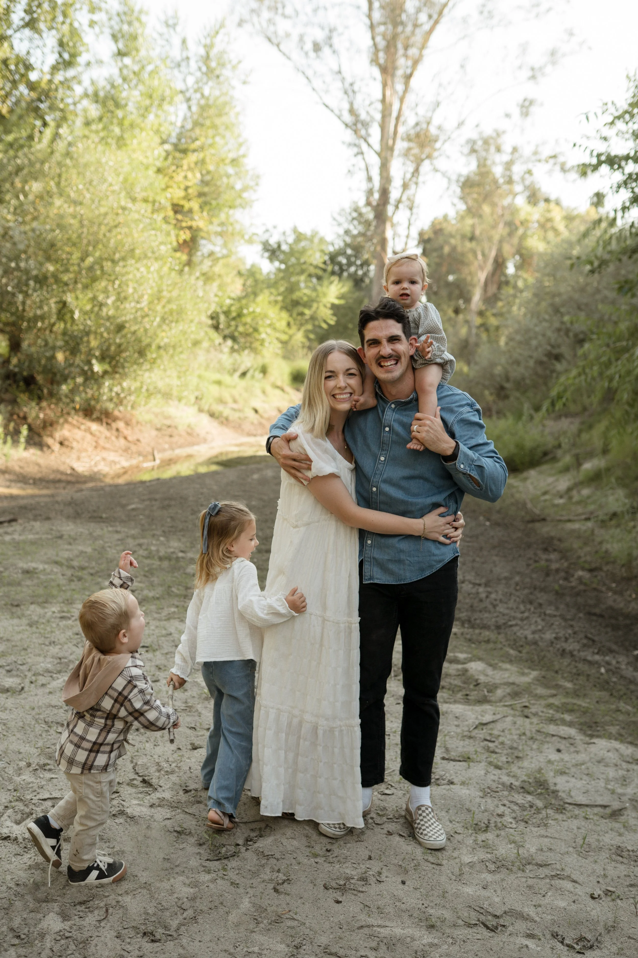 About page image. Yound family laughing and enjoying each other in an outside setting.