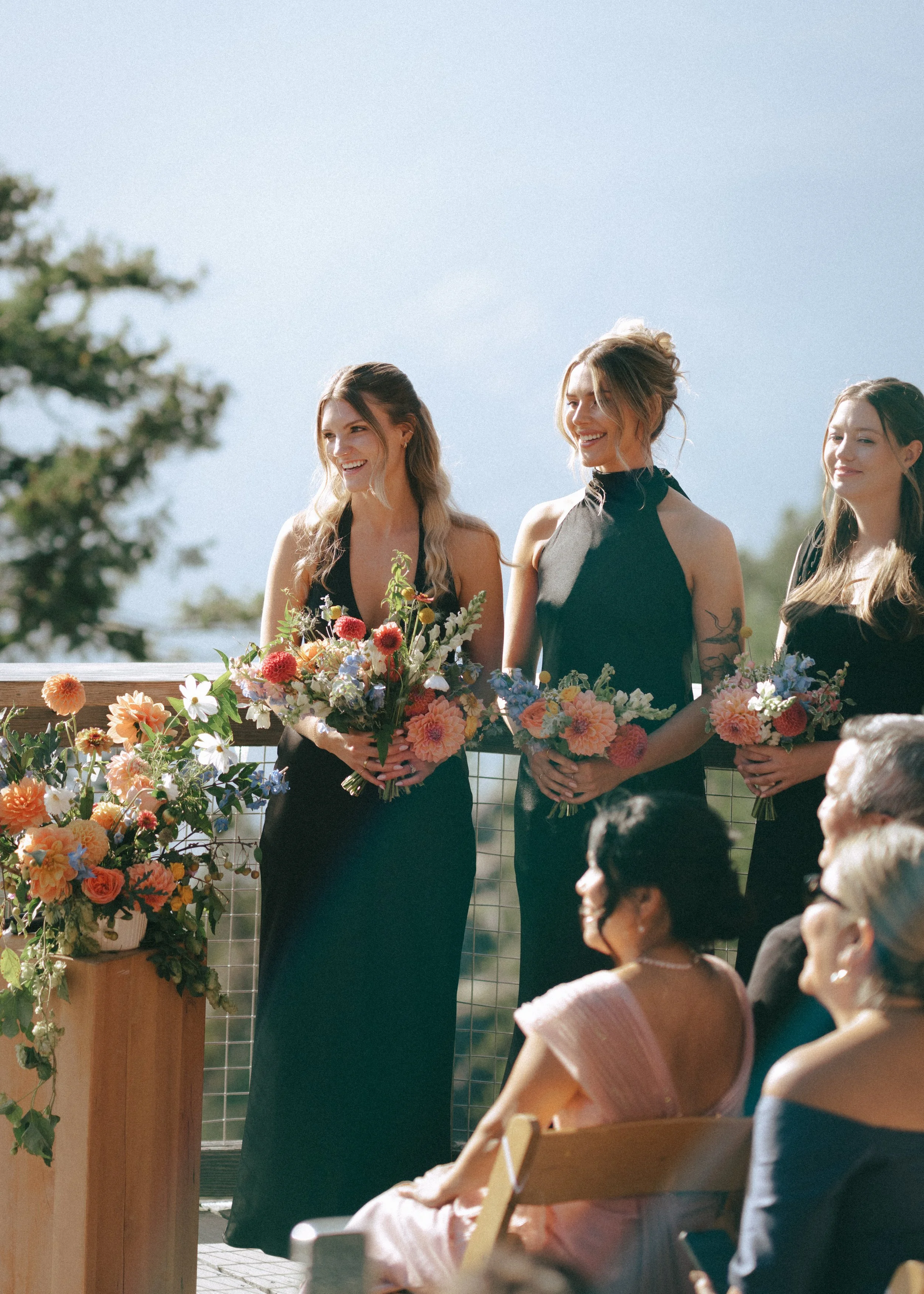 Gloucestershire Gloucestershire Wedding Flowers. Wedding Florist Stroud, Bristol and the Cotswolds. They are holding colorful flower bouquets and smiling. Luxury wedding florist. 