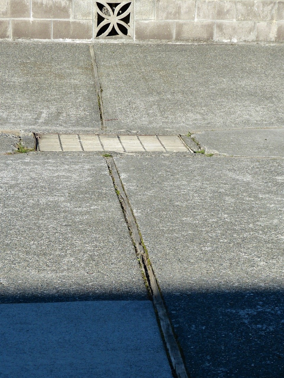 Cement surrounding the drain is deteriorated so bad that water runs under the driveway instead of into the drain.