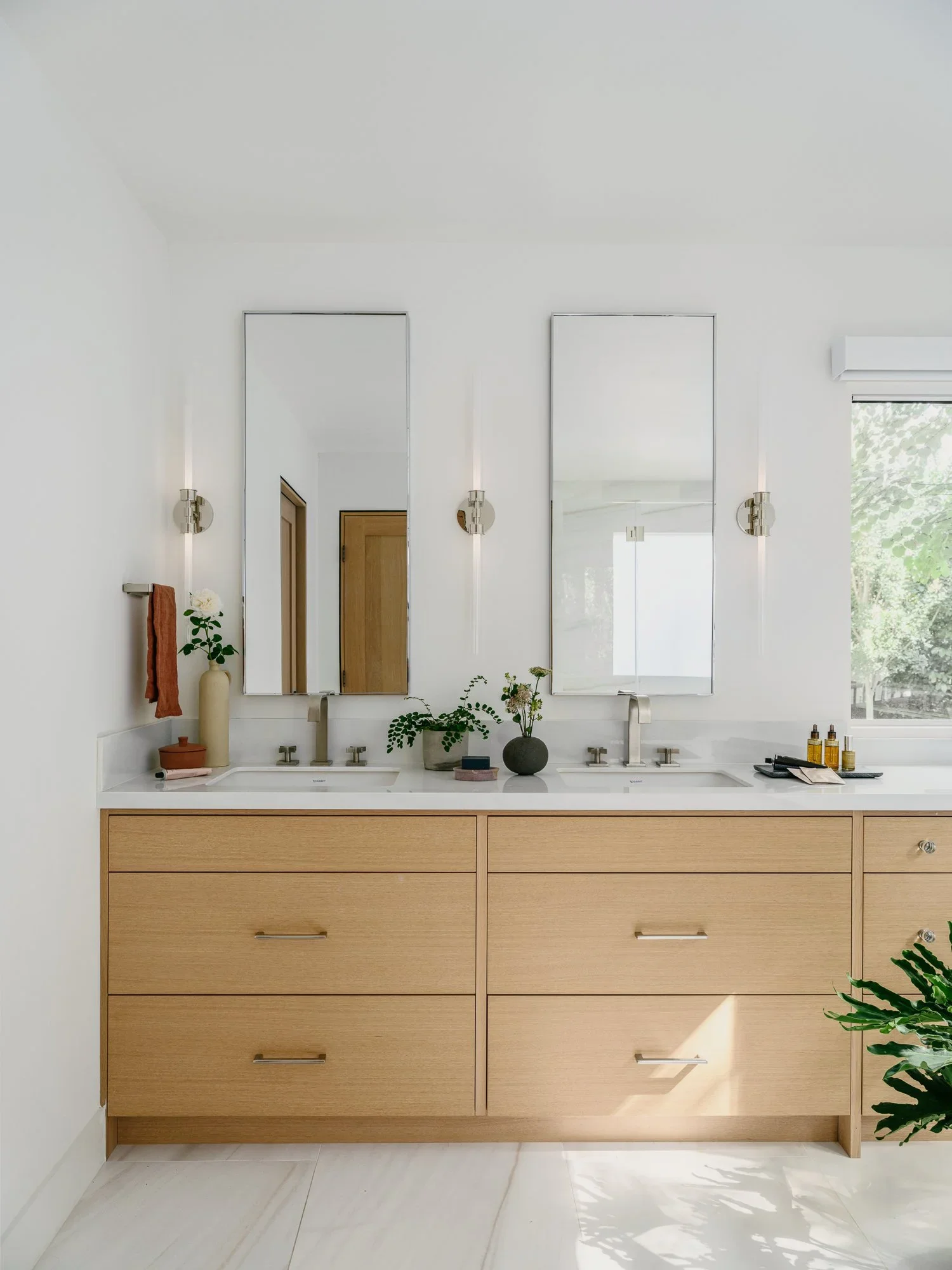 
Primary bathroom double vanity with natural oak cabinetry, dual rectangular mirrors, brushed nickel sconces, and white quartz countertop — Lafayette California home remodel by Mokume Design Studio