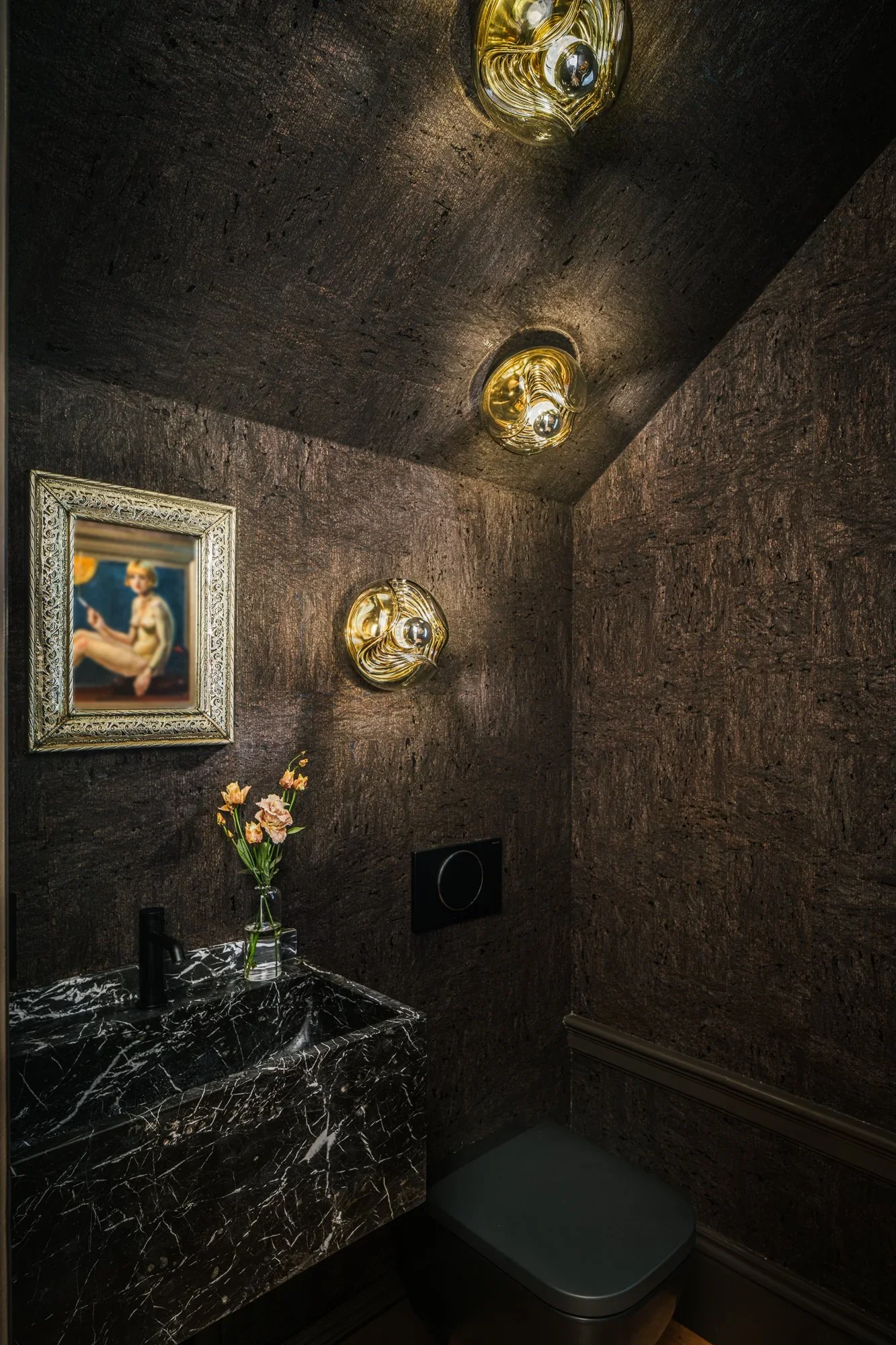 Dramatic powder room with full cork wall and ceiling texture, black marble vessel sink, gold sculptural sconces, and ornate framed artwork — Hill Street Residence San Francisco by Mokume Design Studio