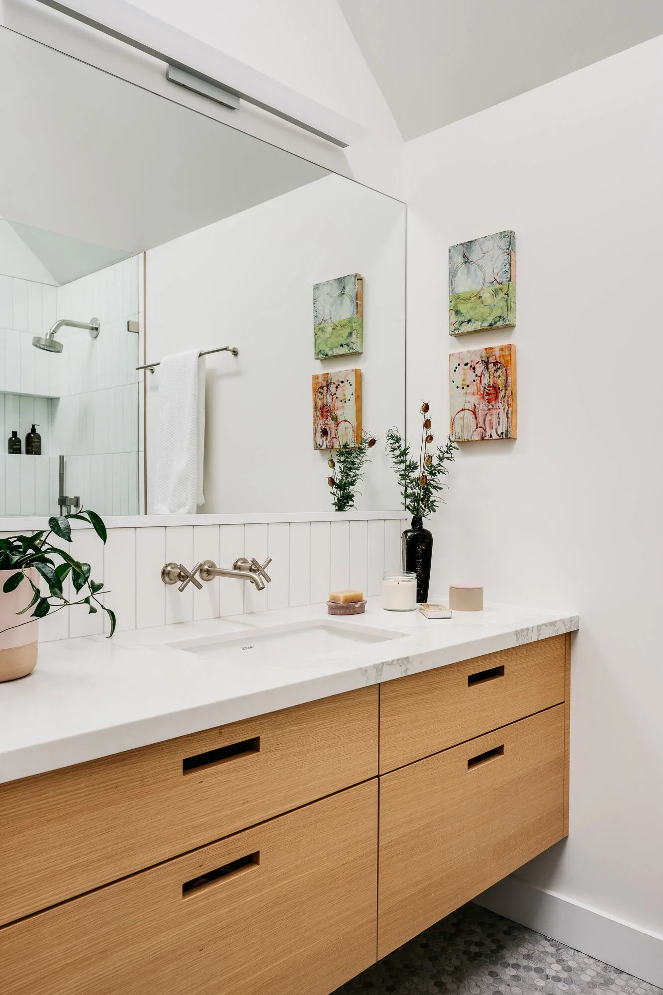 Floating natural oak bathroom vanity with white quartz countertop, wall-mount brushed nickel faucet, shiplap backsplash, and hexagon tile floor — Nopa Loft San Francisco by Mokume Design Studio