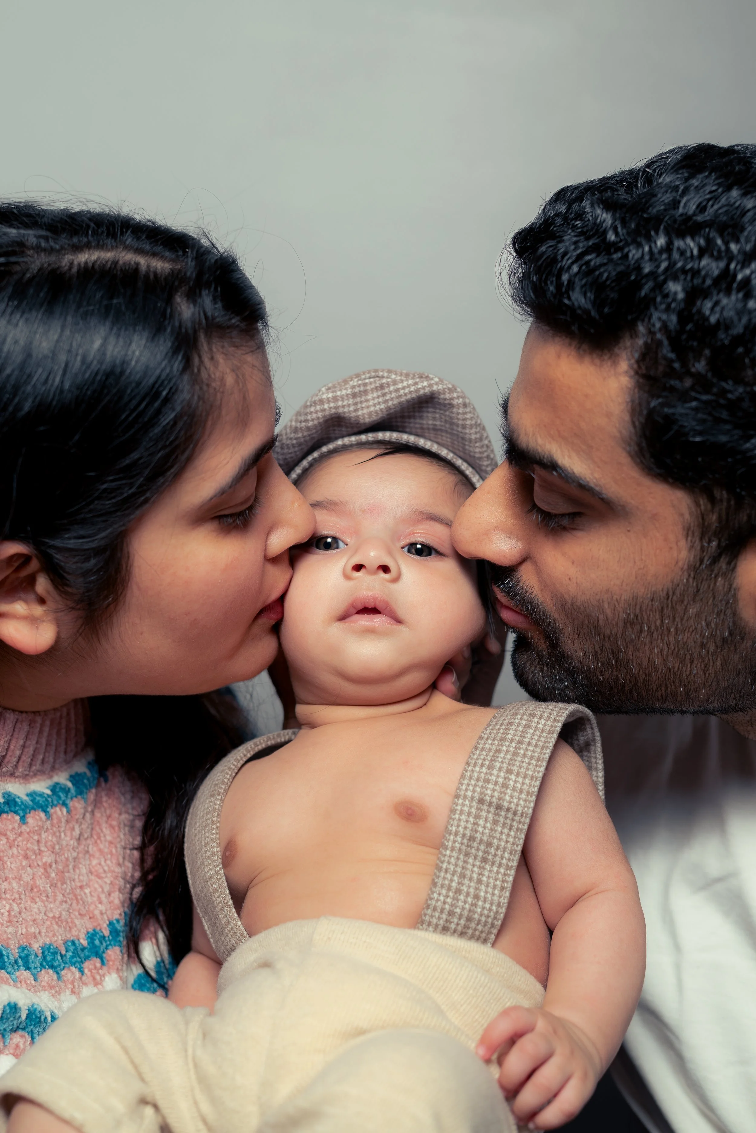 Parents kissing their newborn baby | Family & Newborn Photography Kitchener Waterloo Ontario by Abhijeet Bhullar