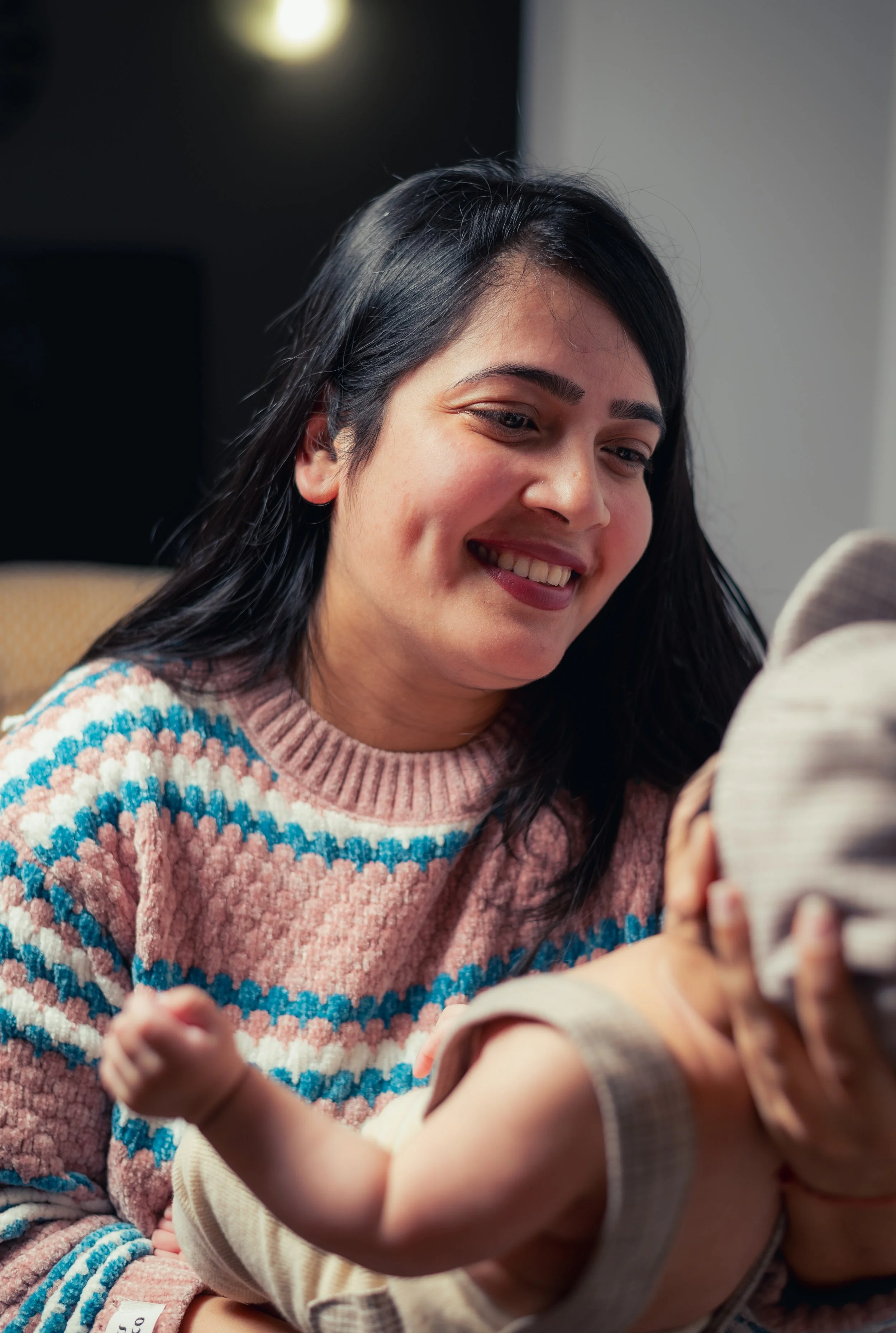 Mother smiling and holding her newborn baby | Family Photography Kitchener Ontario by Abhijeet Bhullar
