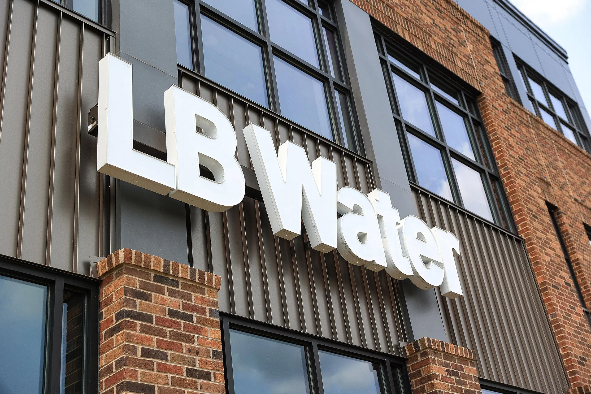Exterior of a building with a sign that reads 'LBWater' mounted on the wall.
