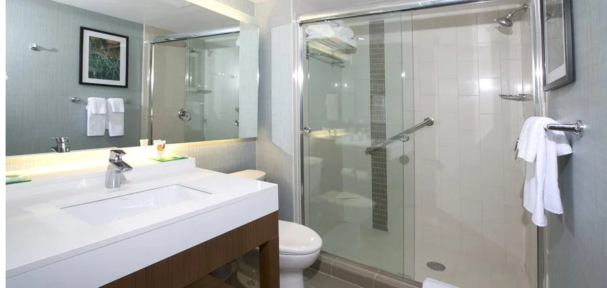 Bathroom with vanity mirror, sink, and shower enclosure with glass doors.