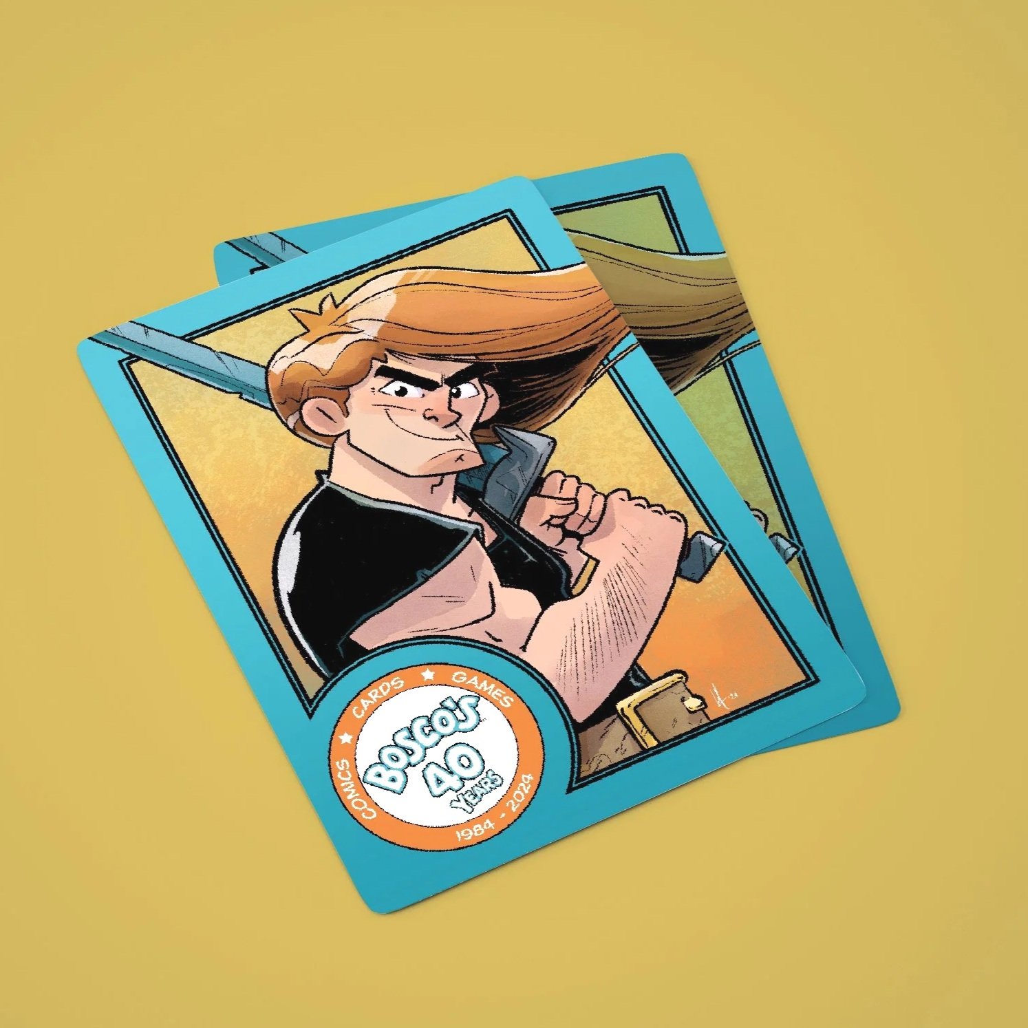 Stack of vintage-style trading cards featuring a cartoon character with long hair holding a sword, with a round logo at the bottom left corner indicating 'Boscos AO' and noting '1984 - 2024'.