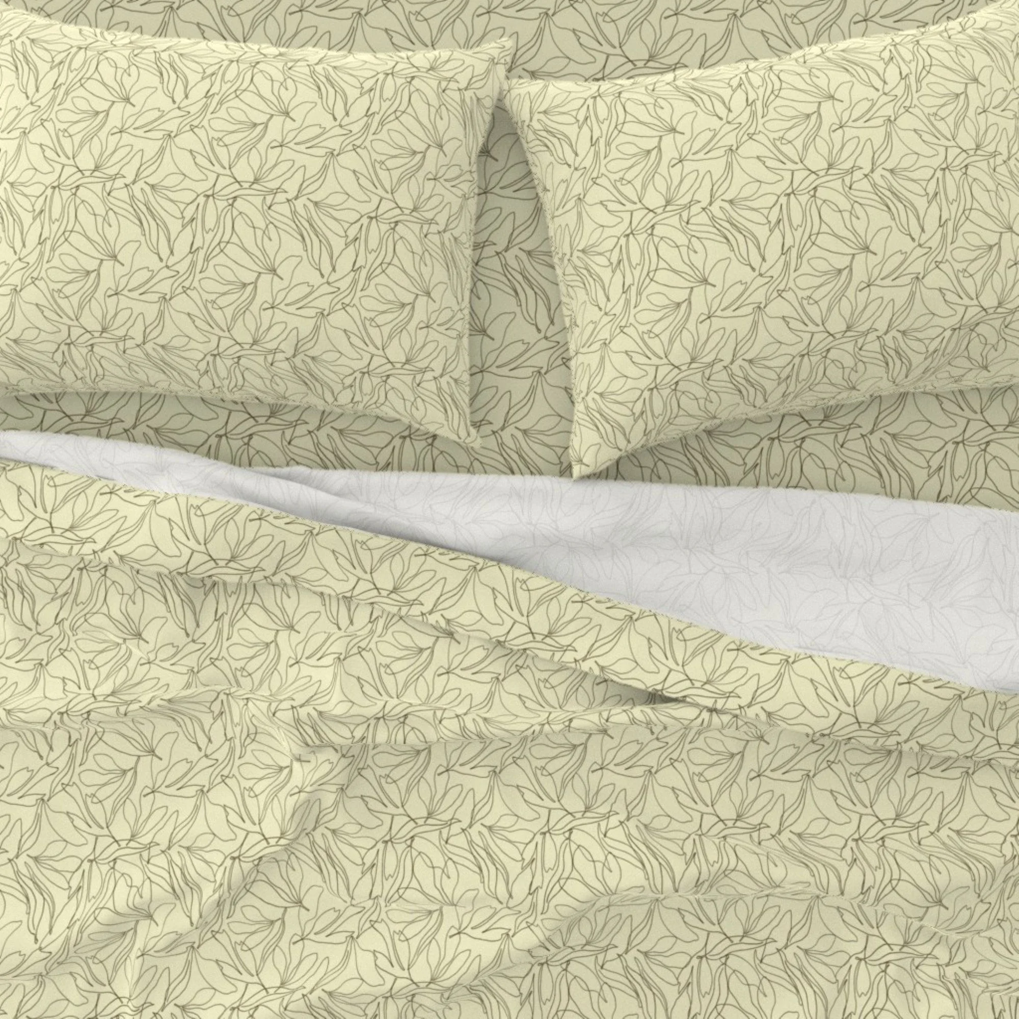 A bed with a matching pillow and bedsheet, all featuring an allover hand drawn line leaf pattern.