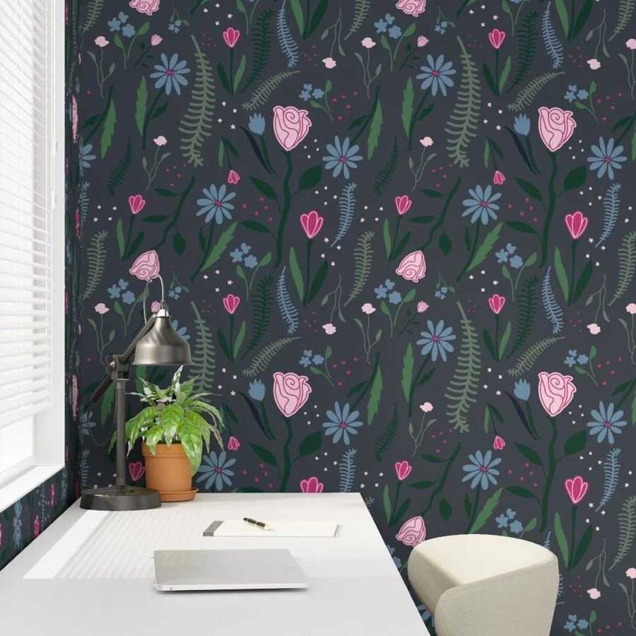 Maximalist floral wallpaper, from the Deep Bloom collection, with pink and blue flowers on a dark gray background, shown on wallpaper in an office setting.