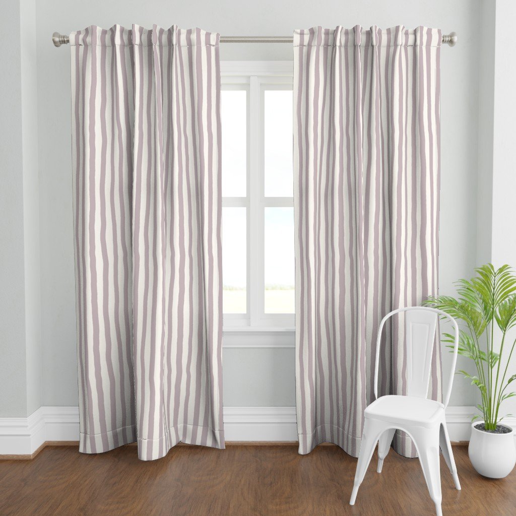 Light mauve and cream striped curtains hanging in front of a window in a bright room, with a white chair and a potted plant nearby.