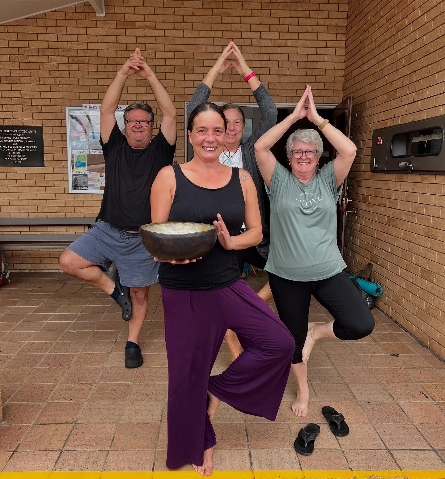 Kate with her yoga students in tree pose.