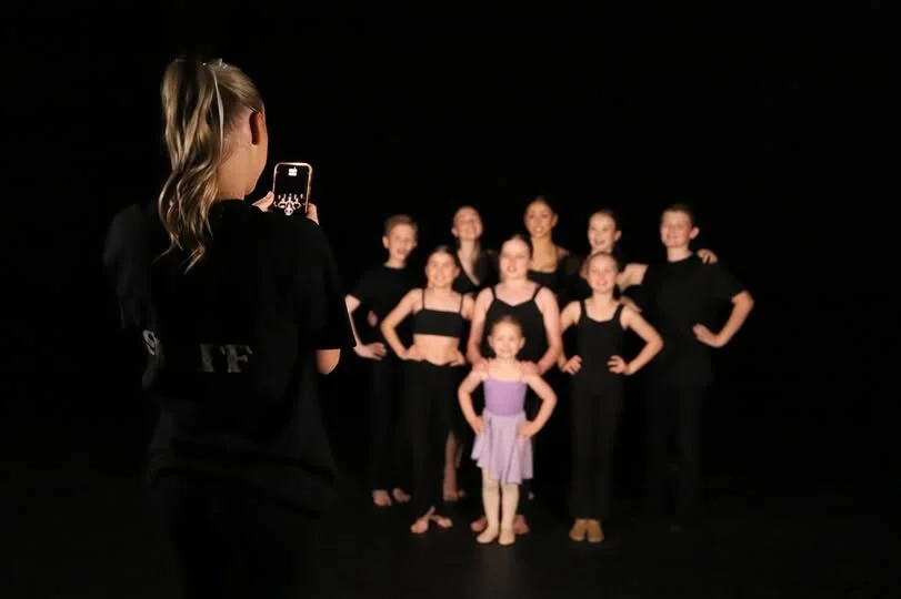Dance Teacher photographing a group of dance students.