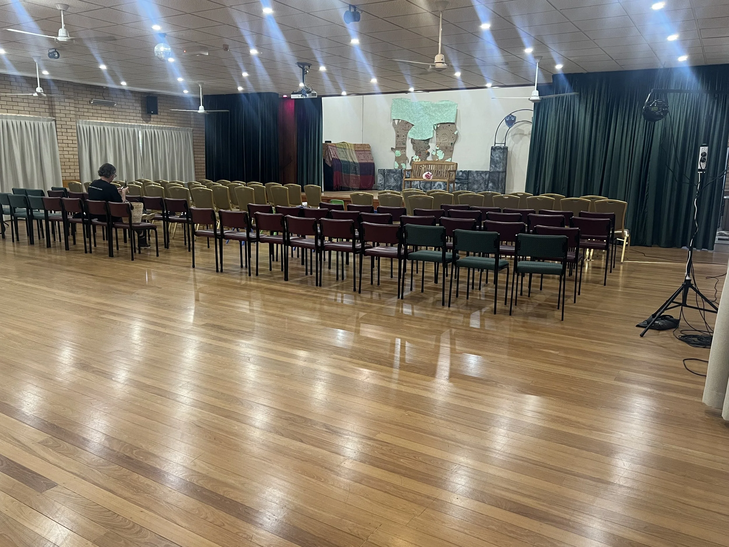 Main Hall with stage set up for performance and chairs in rows for audience