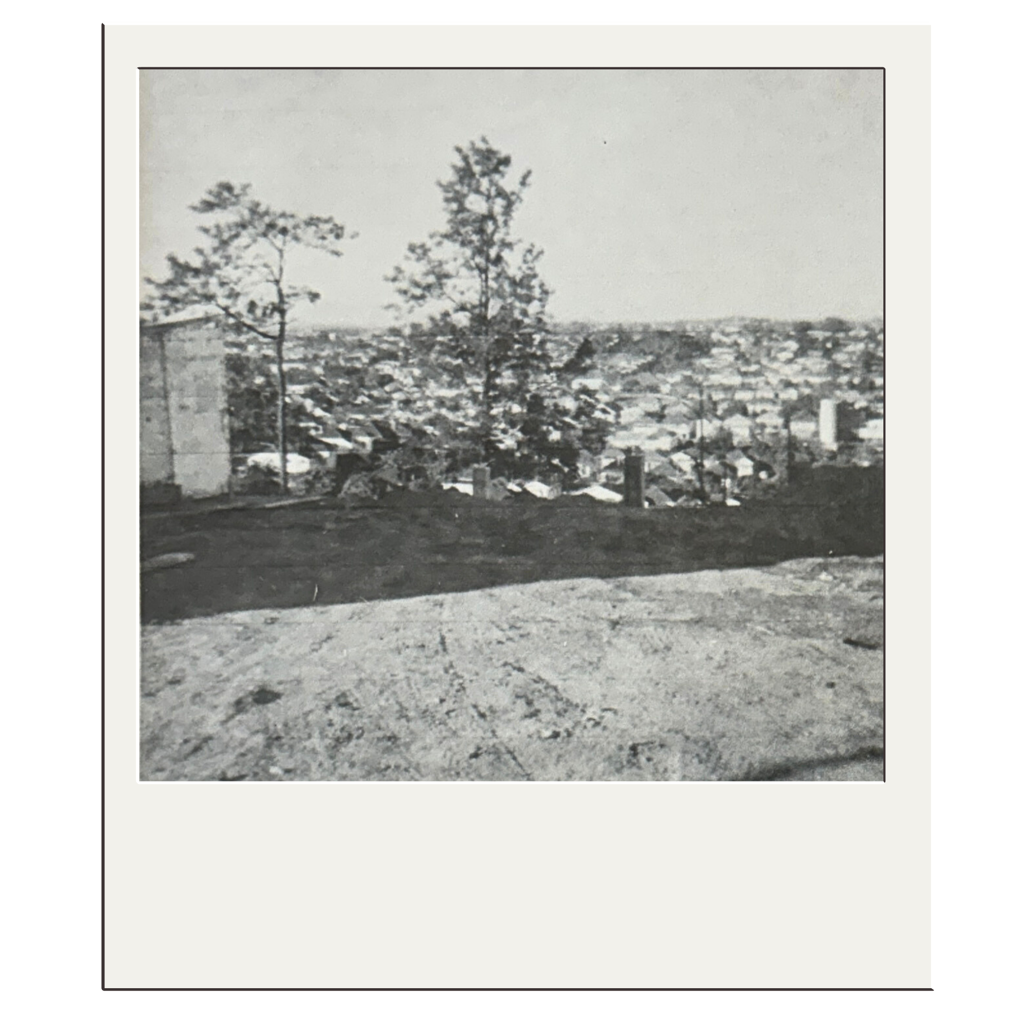 Black and white photo of building site looking out over the suburb of Rosalie