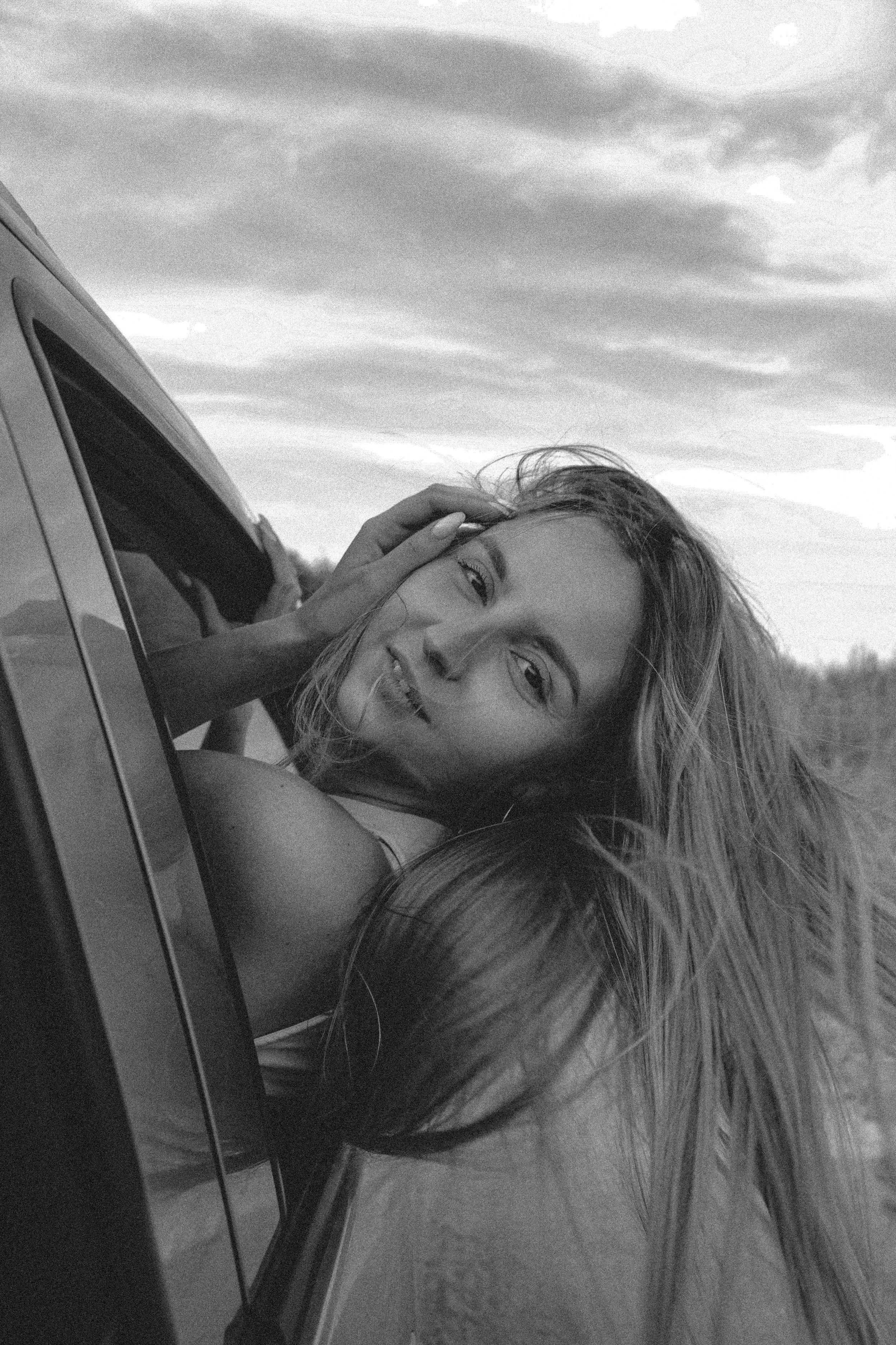 Woman in car, feeling happy and content.