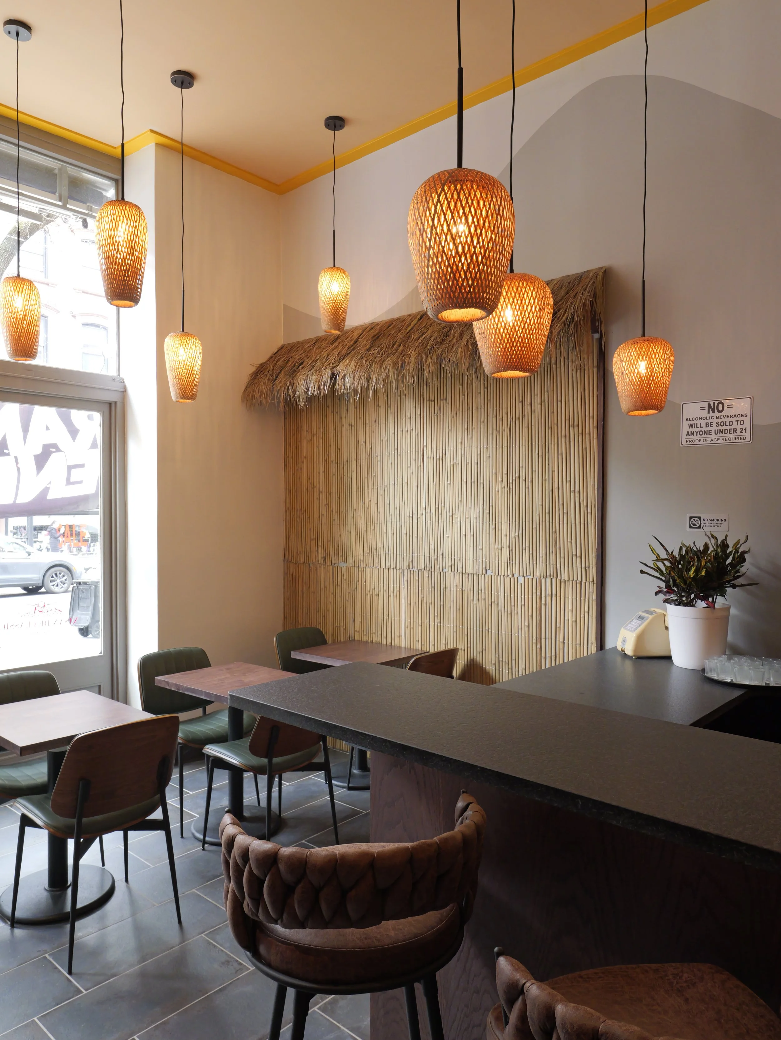 Intimate corner dining setup with decorative bamboo framing. Unique interior design features that create a memorable customer experience. Design-build services by XZ Design Build